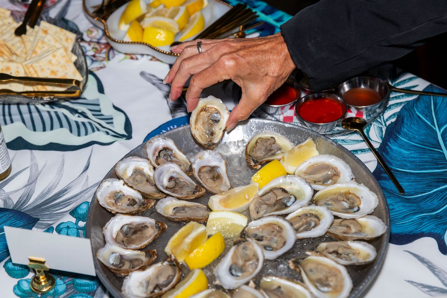 Fresh oysters on ice with lemon wedges served on platters at an event.