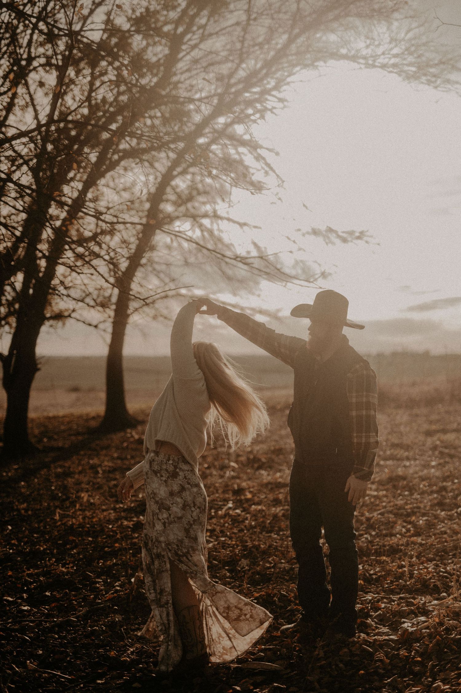 Artistic silhouettes of two people in an autumn forest with dramatic lighting.