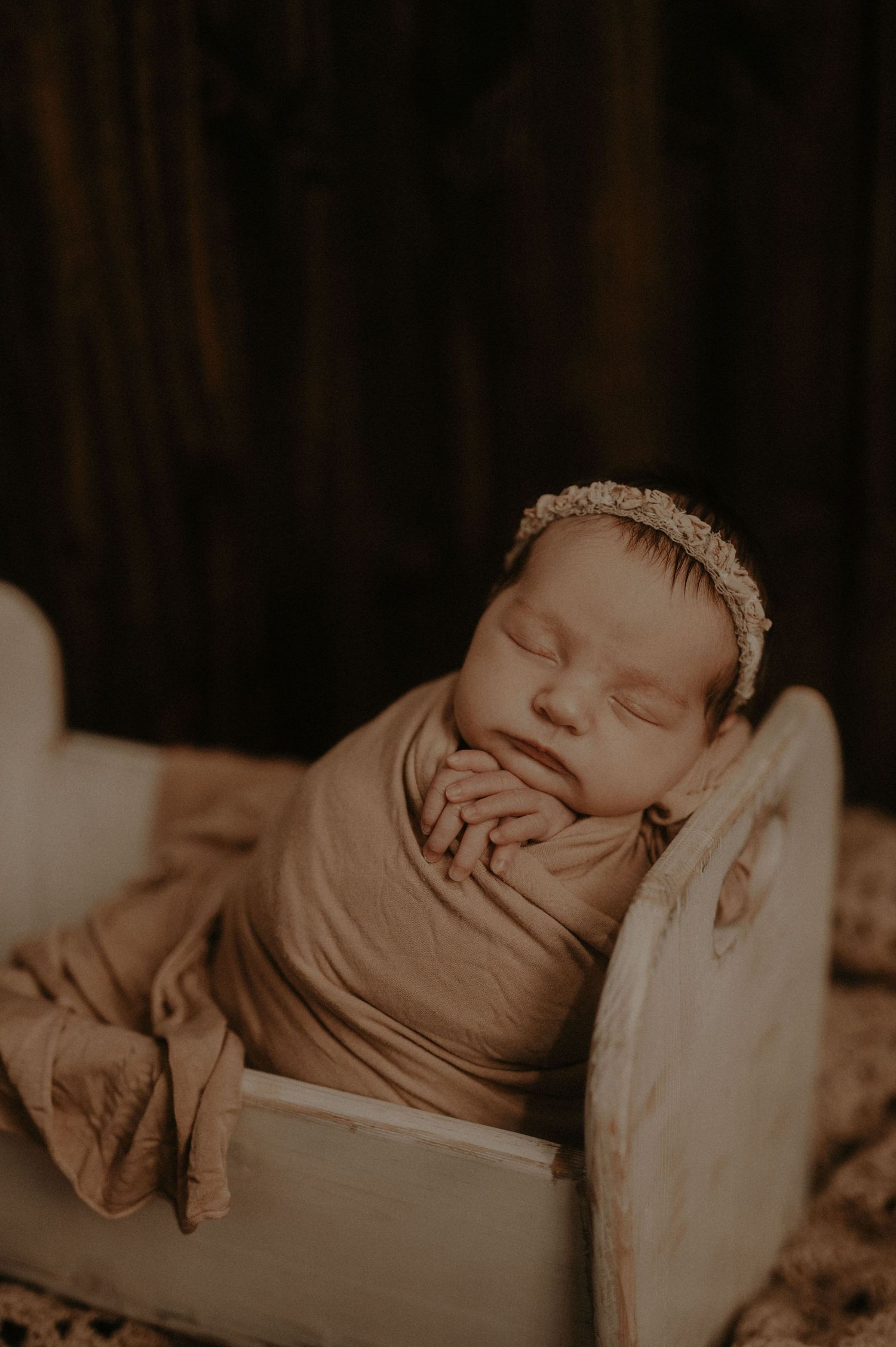 A sepia-toned series of close-up photos showing a sleeping baby in various peaceful poses.