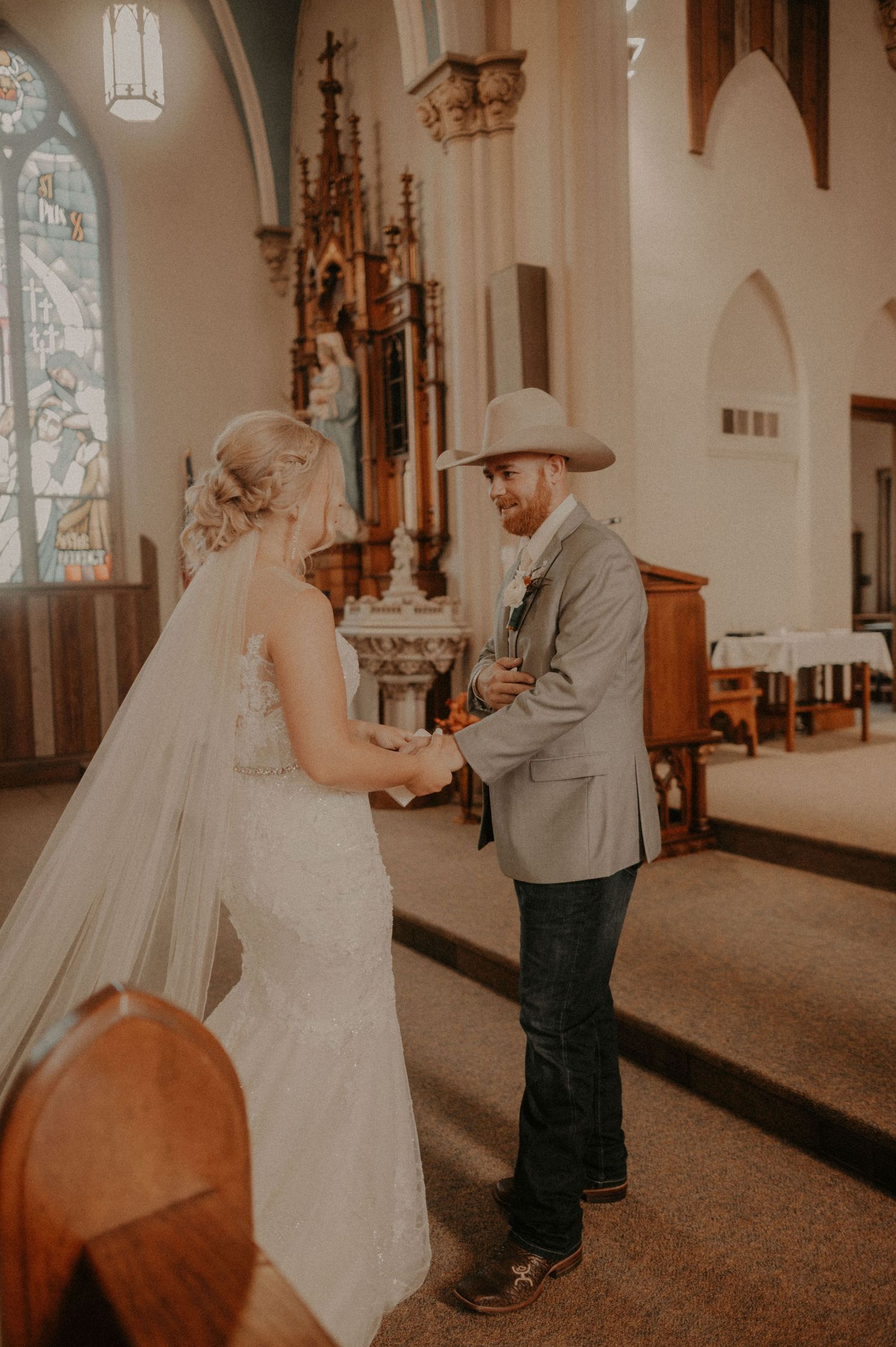 Wedding couple sharing an intimate moment in a historic church sanctuary with gothic architecture.