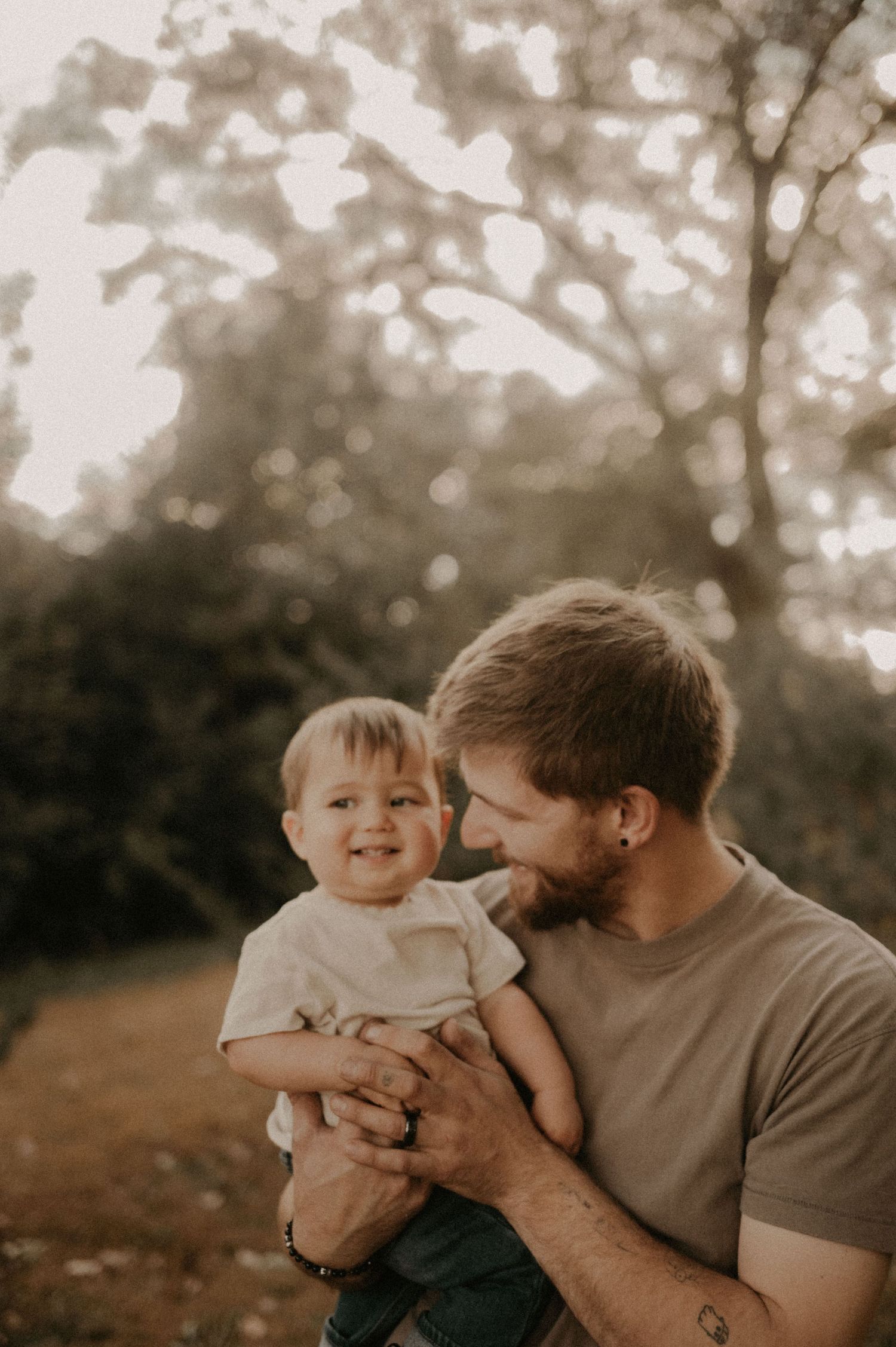 Sweet candid moments between parent and baby in a warm outdoor setting.