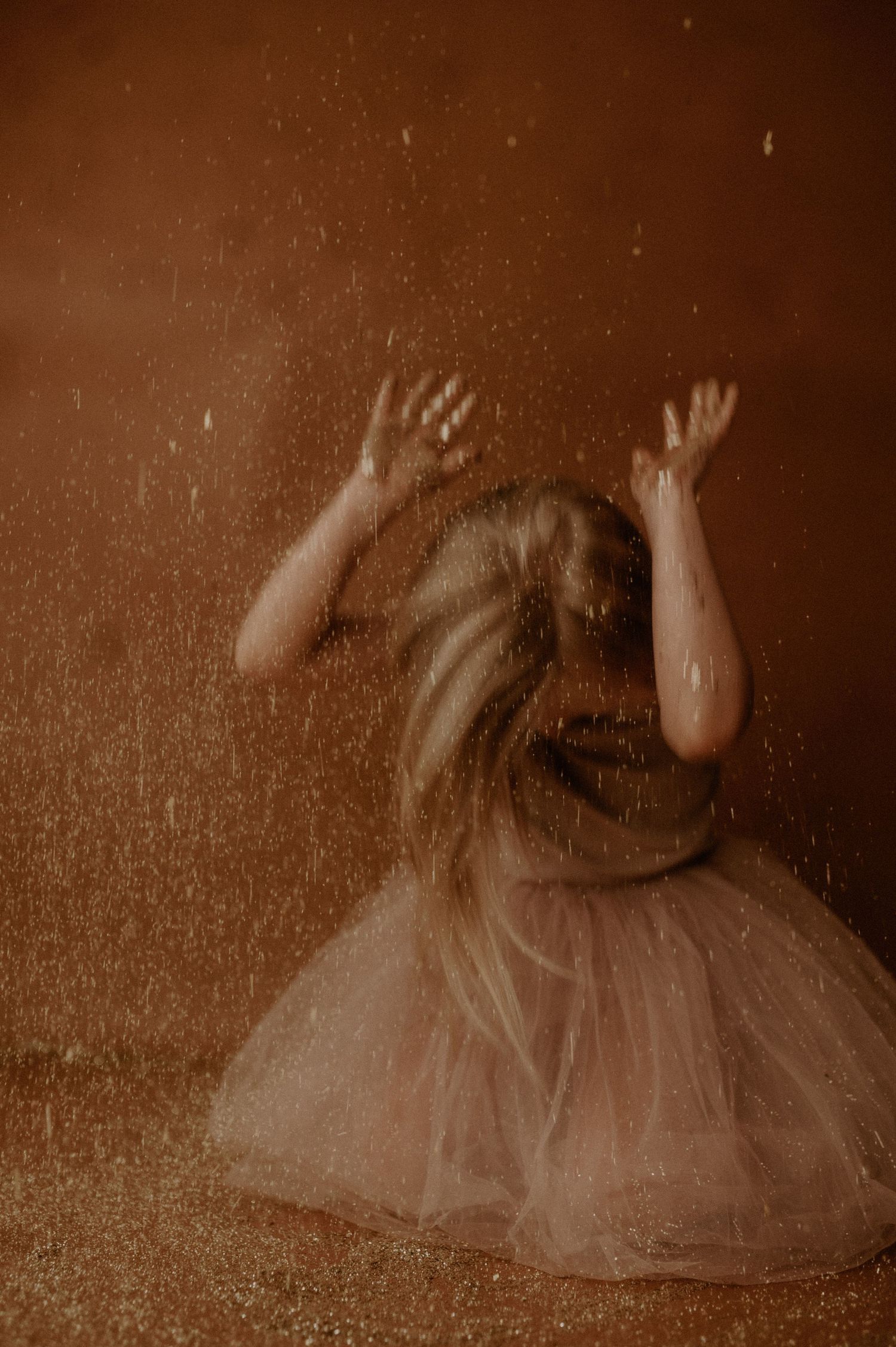 A series of sepia-toned photographs showing a dancer in a tulle dress performing graceful movements across the frame.