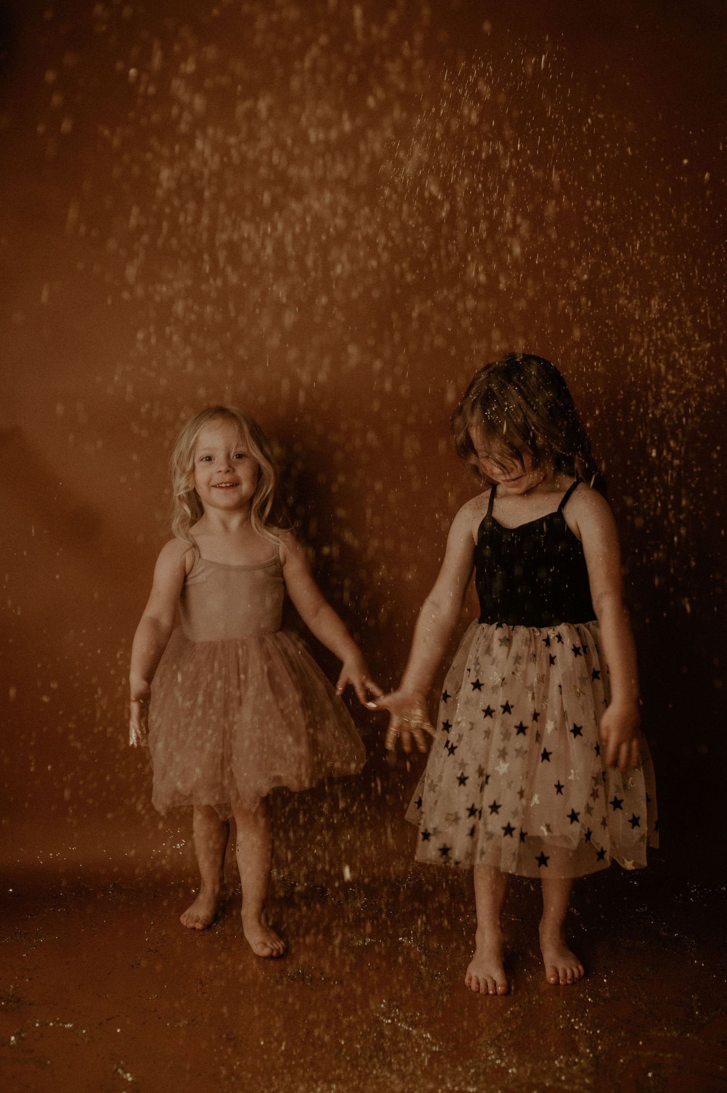 A sepia-toned sequence shows children playing and jumping in falling glitter against a dark background.