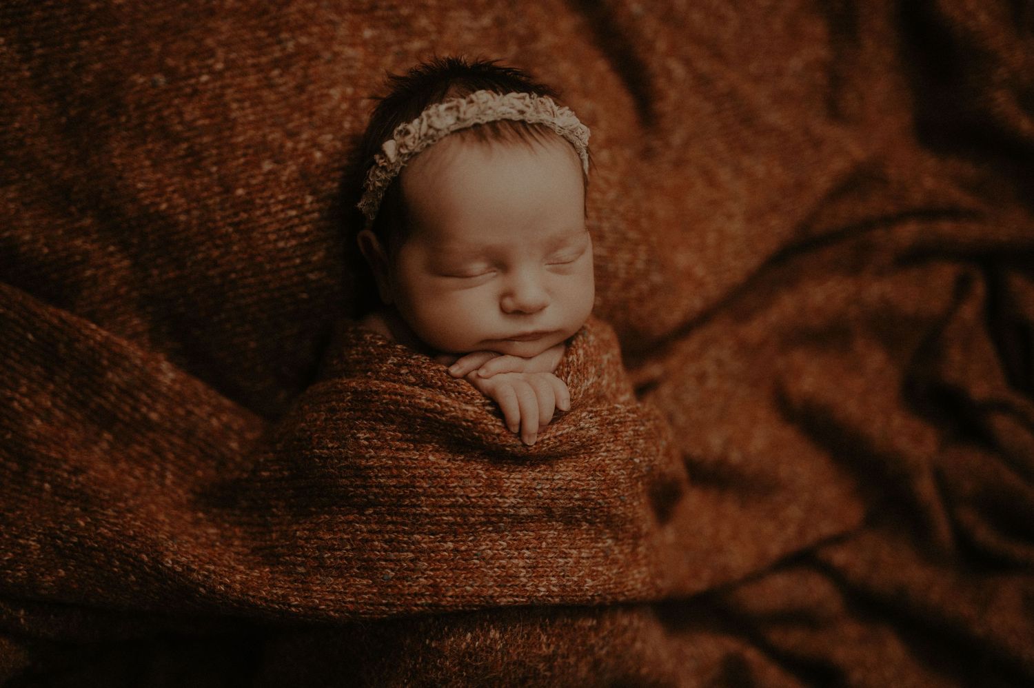 A series of artistic newborn photography portraits featuring soft brown tones and gentle lighting.