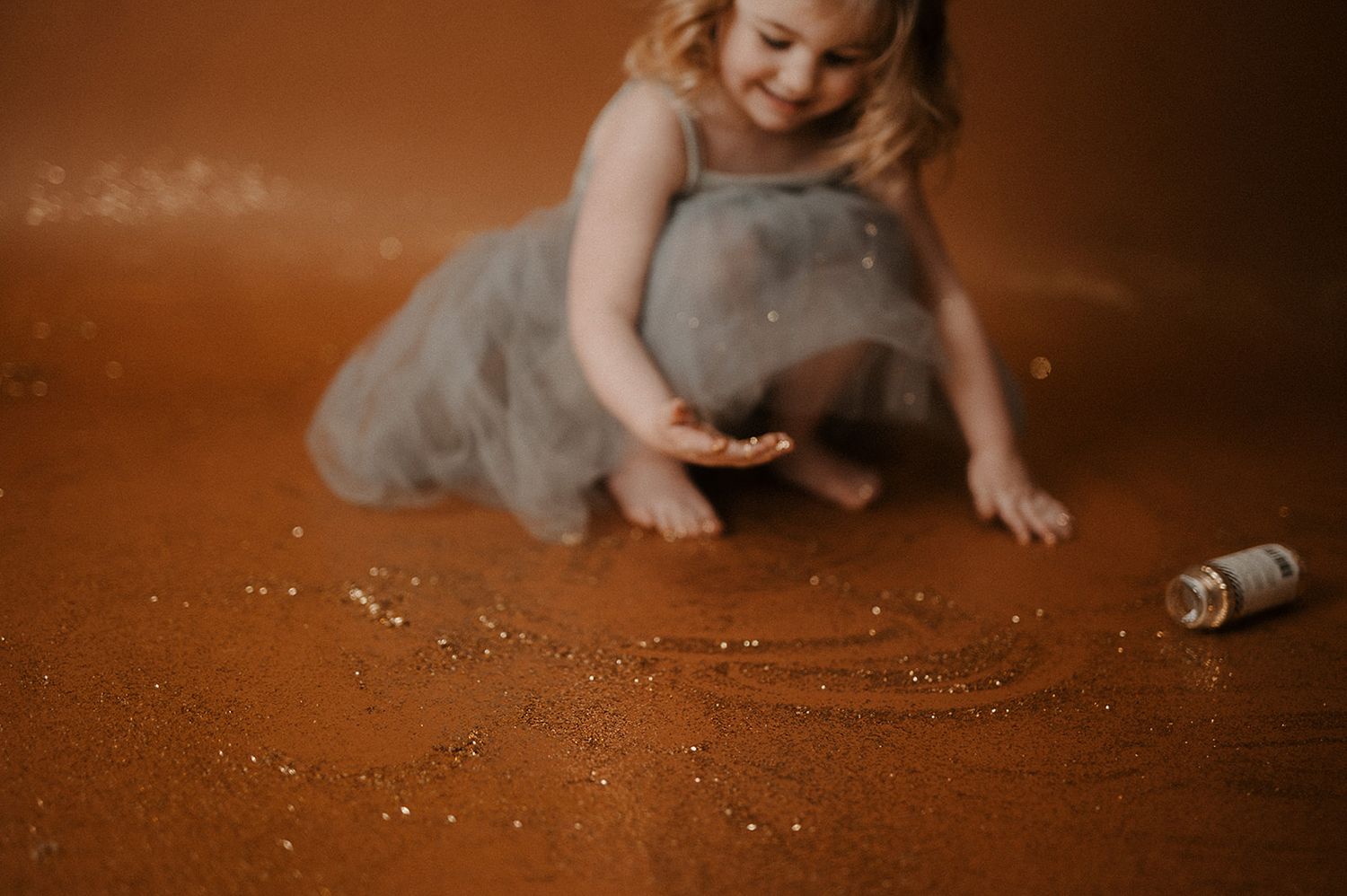 A child crawls playfully on a brown studio backdrop in a series of connected motion shots.