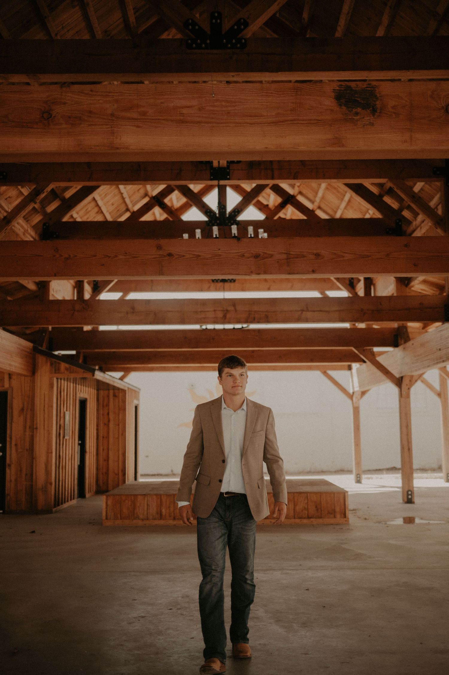 Wooden beams and rafters create a rustic architectural detail in an empty barn interior.