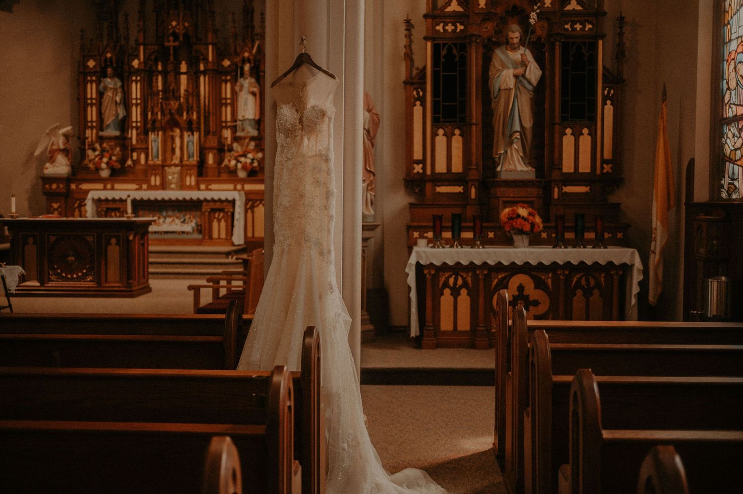 Ornate church altar with wooden pews and religious decorations in warm lighting.
