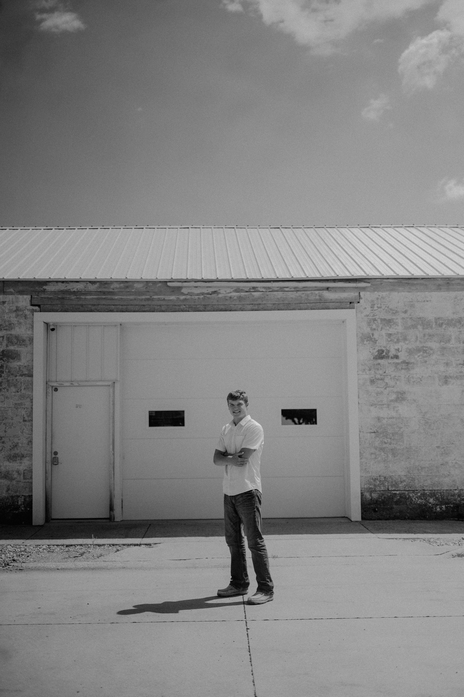 A black and white photo series shows a figure standing in front of a white garage door in different positions.