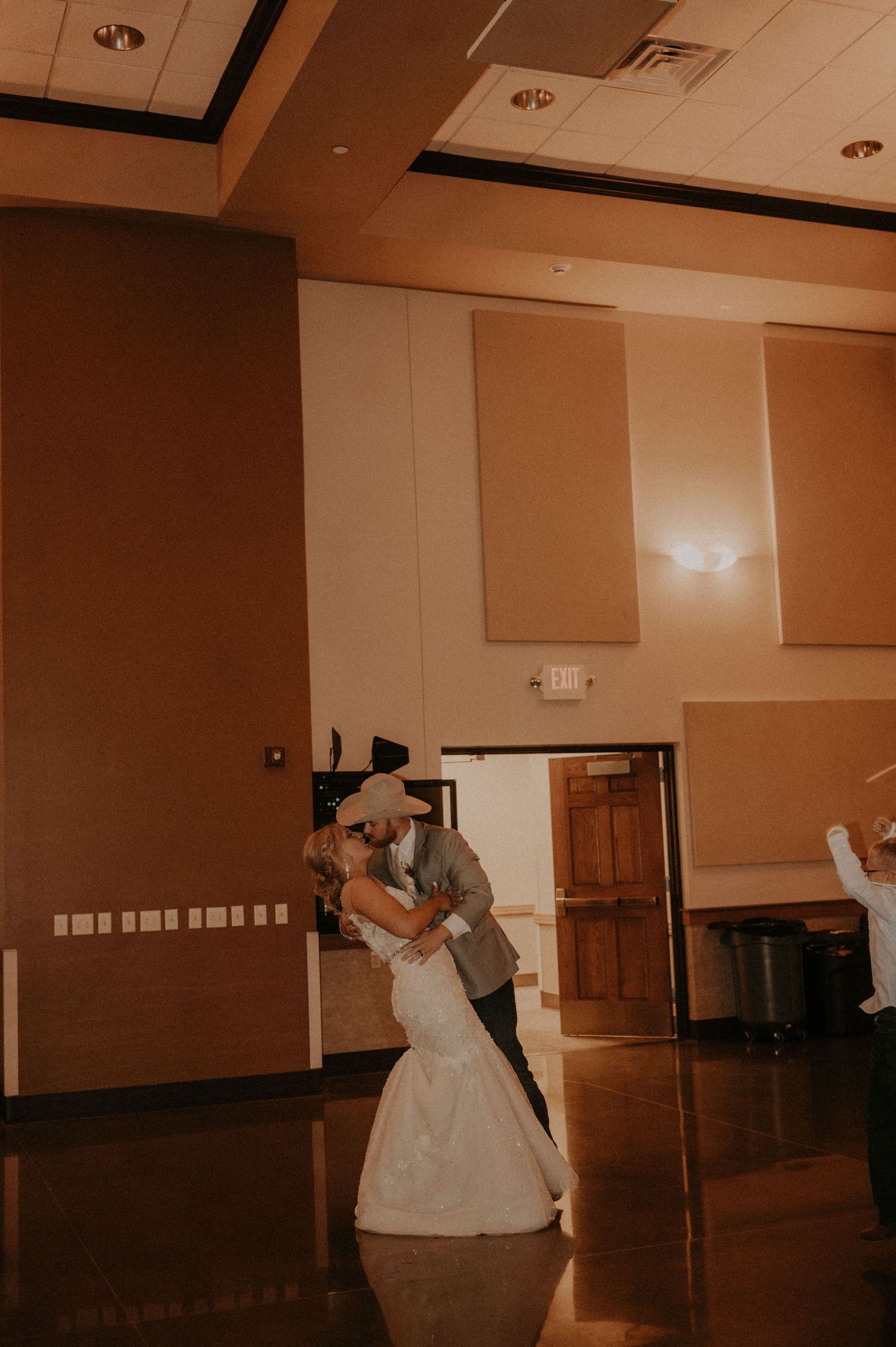 Couple dancing in an intimate moment on empty ballroom floor.