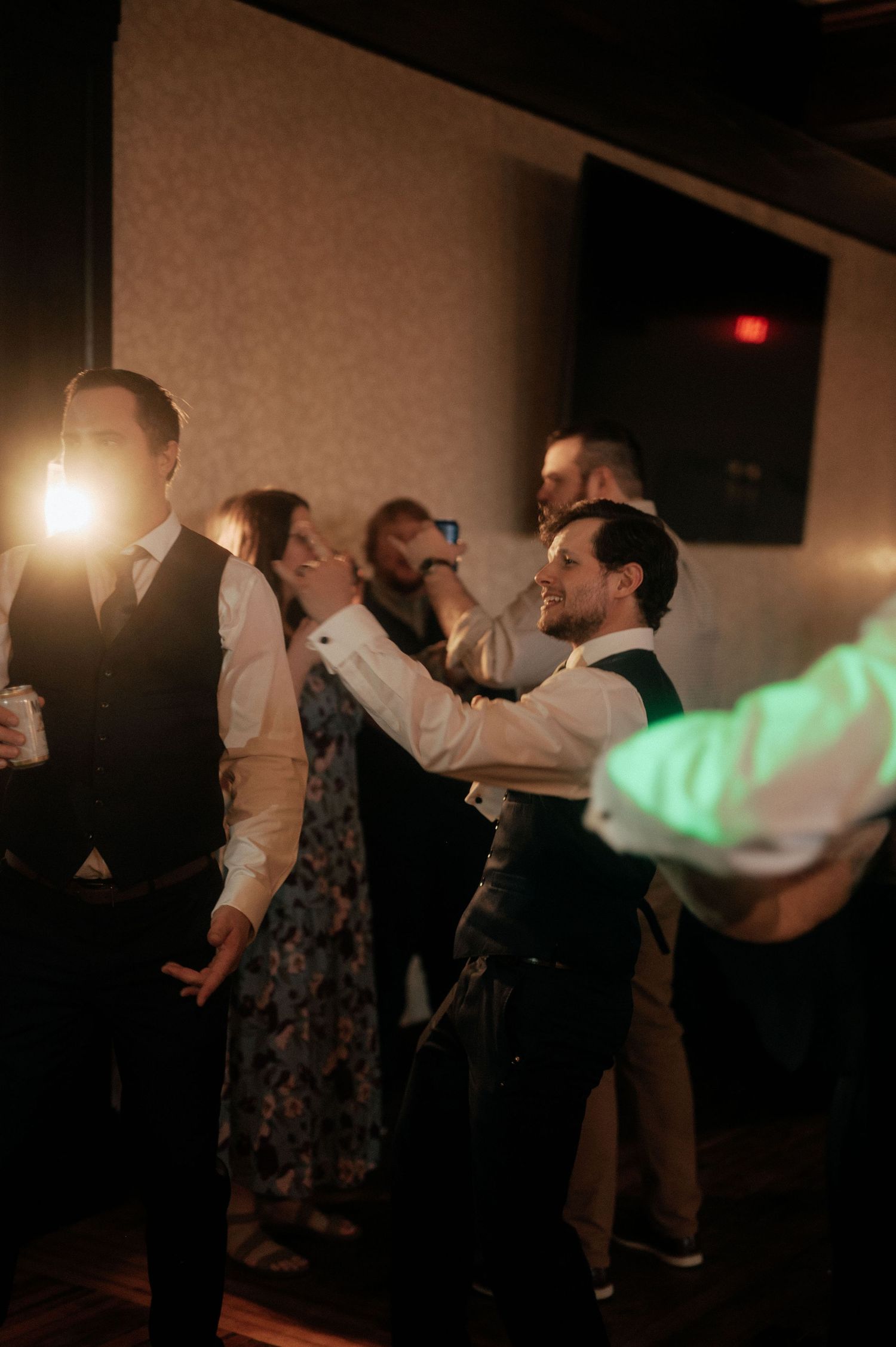 Wedding party members dancing in a line during an evening celebration.