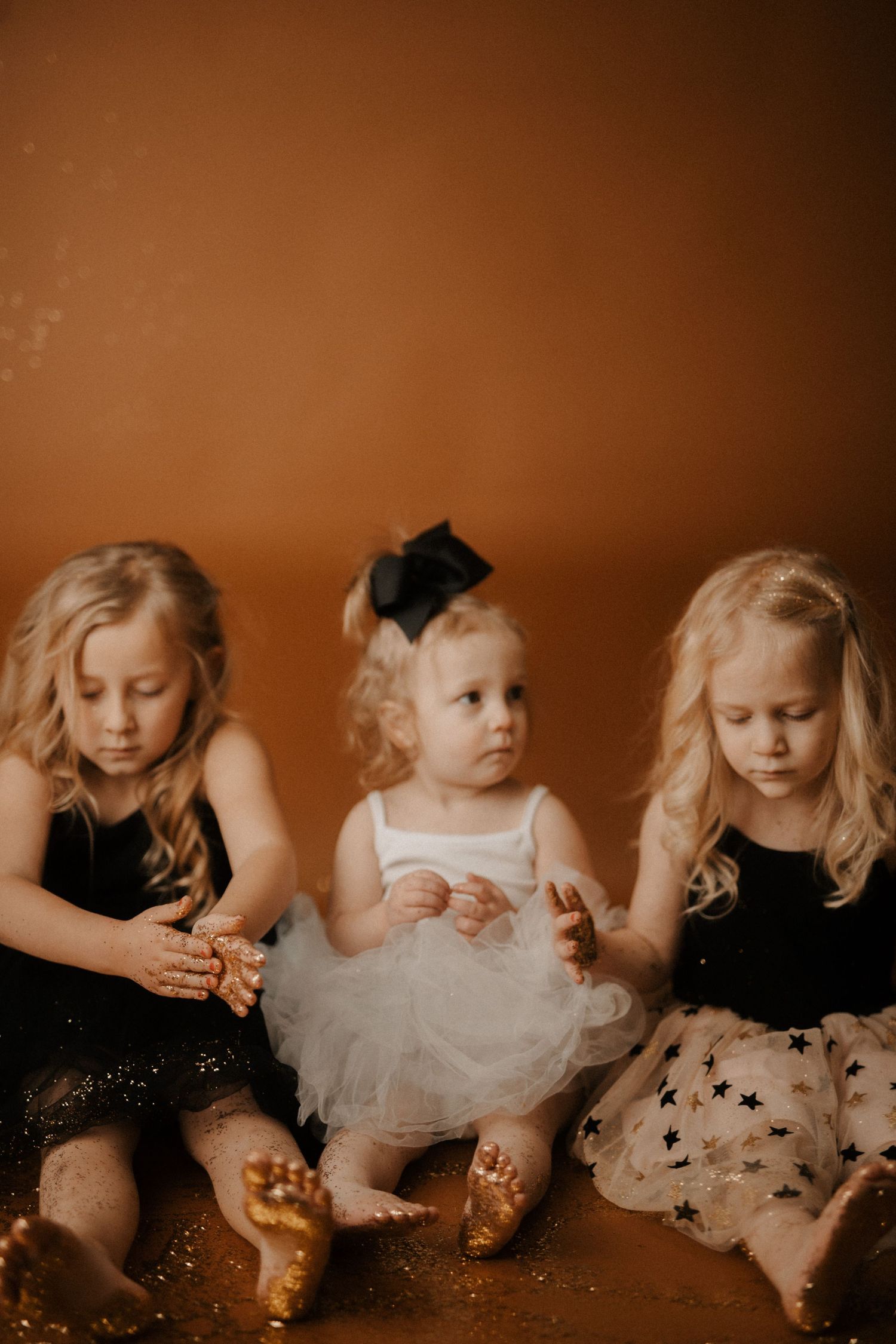 A series of vintage-toned photos showing children in white dresses sitting and playing together in a warm sepia atmosphere.