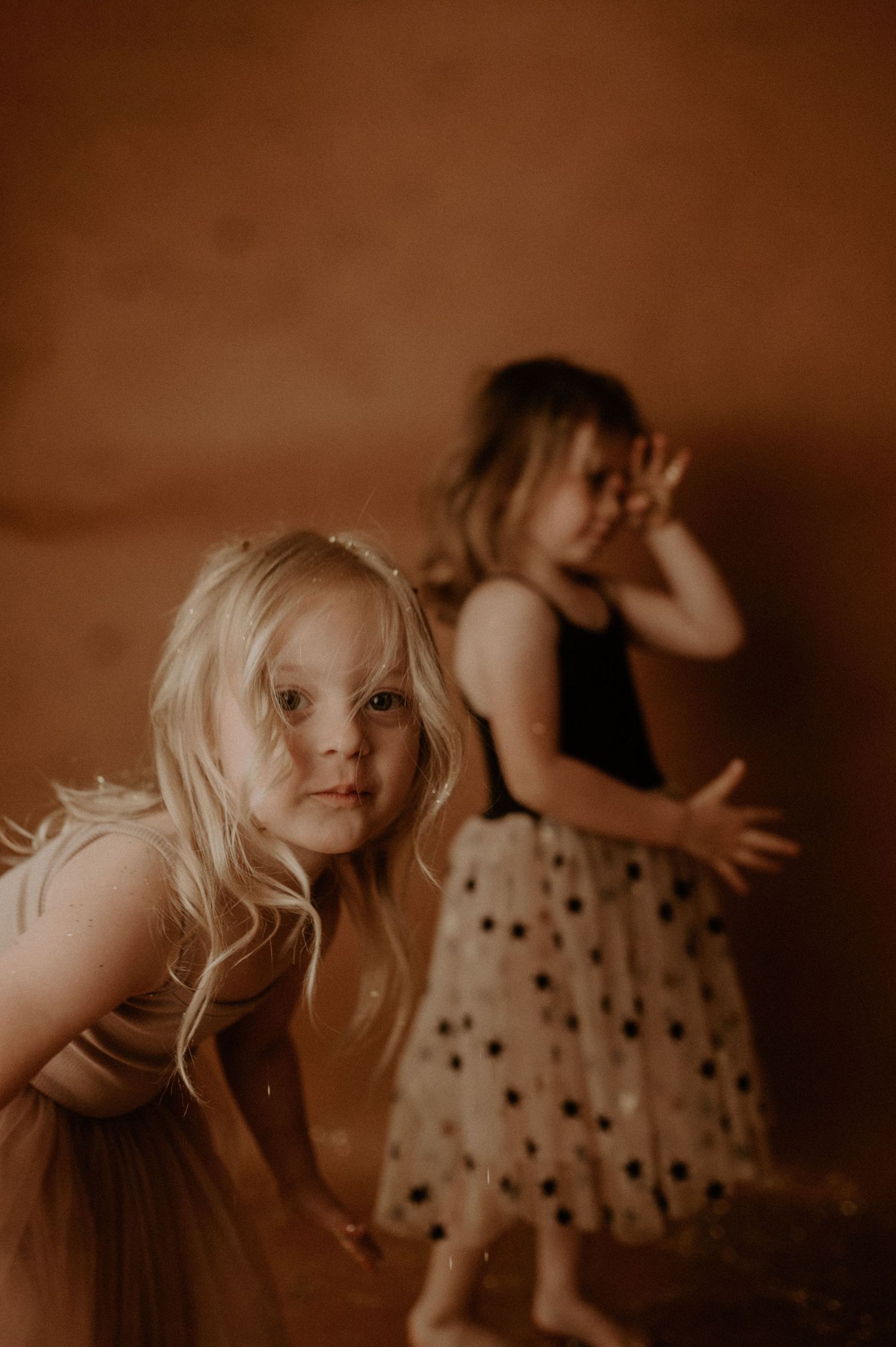 A series of sepia-toned photographs showing a child in a polka dot dress playing and posing in different positions.