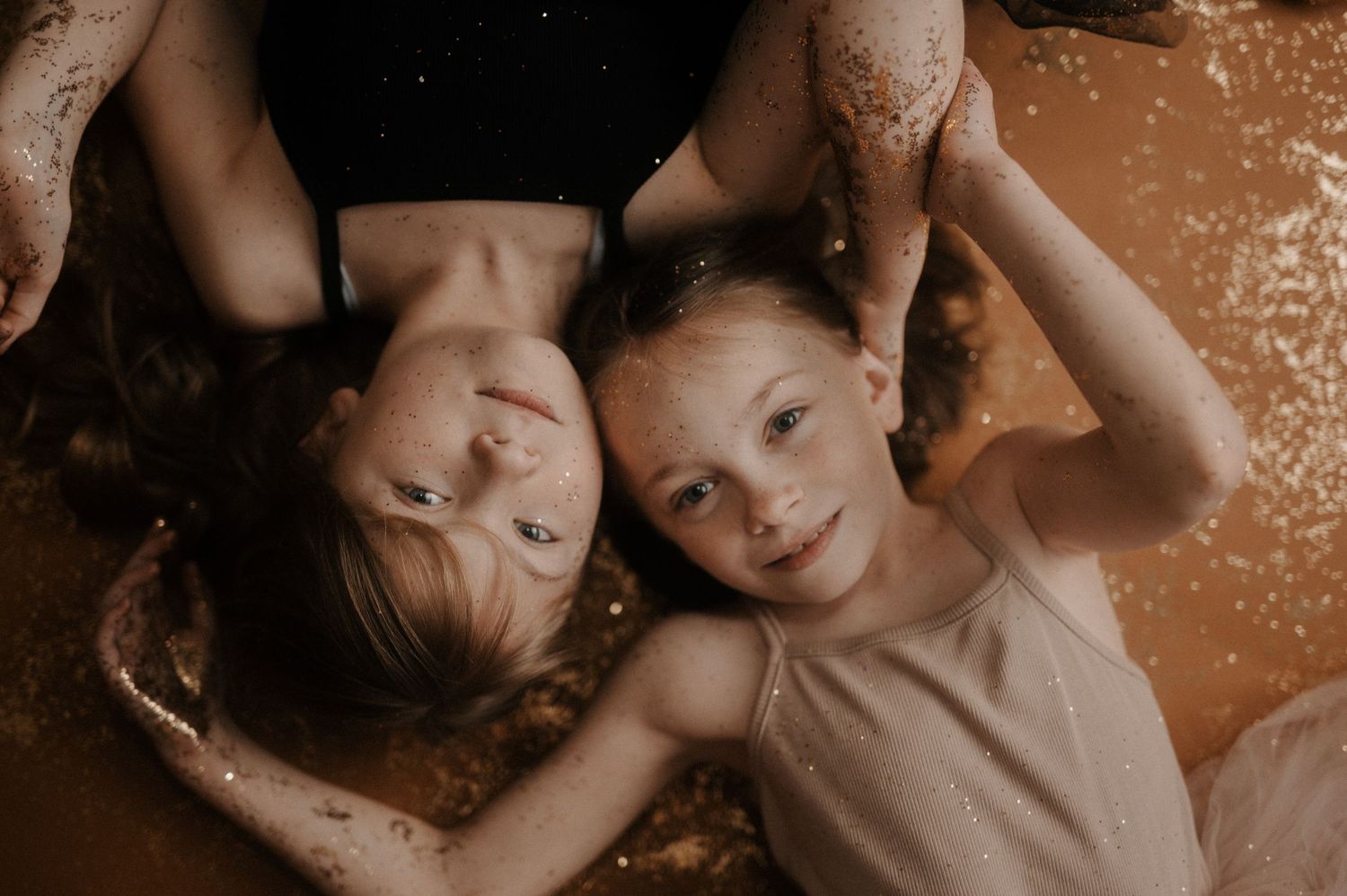 A series of five sepia-toned photographs arranged horizontally showing intimate family portrait moments.