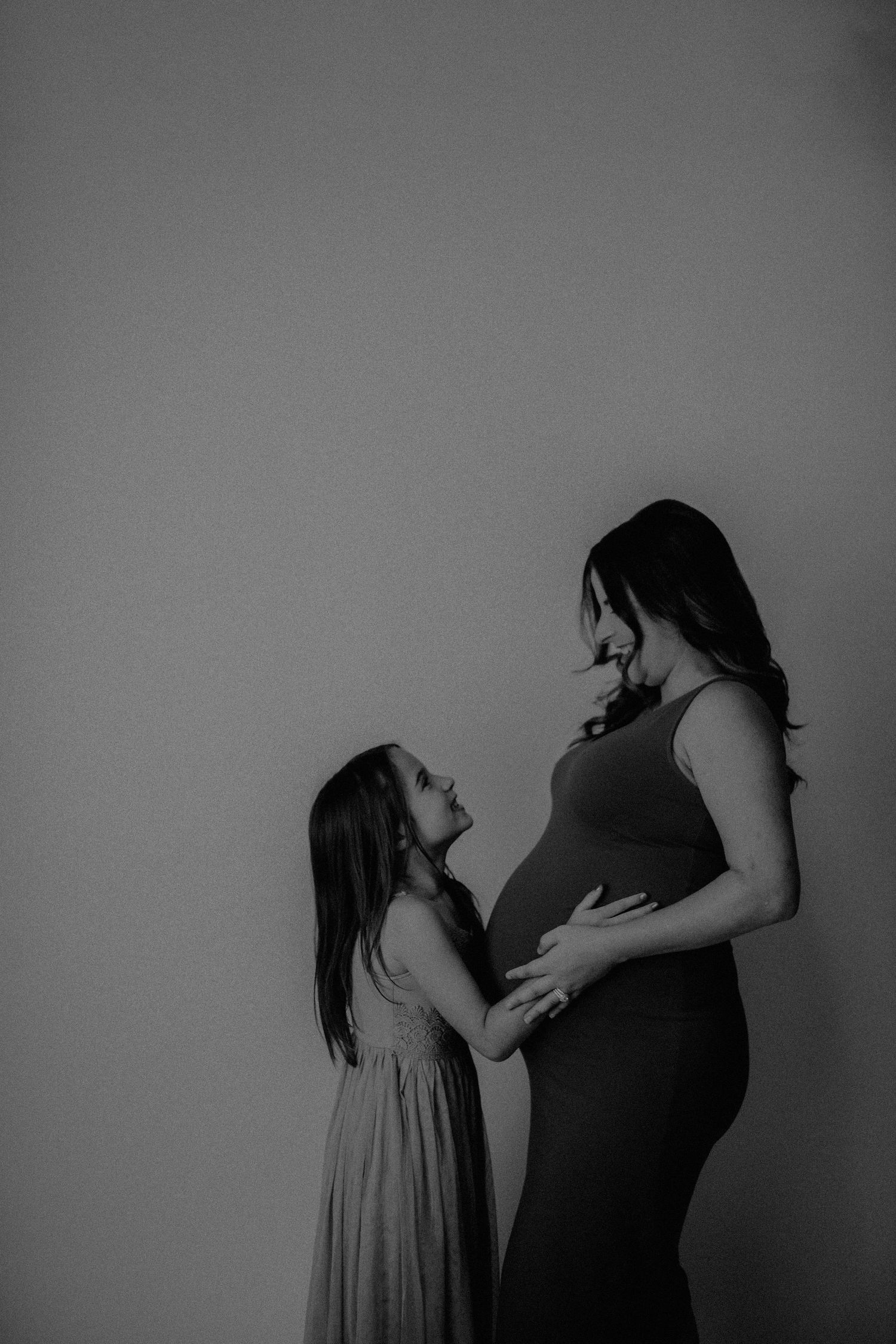 A black and white artistic photo series showing intimate moments between two people in silhouette against a plain backdrop.