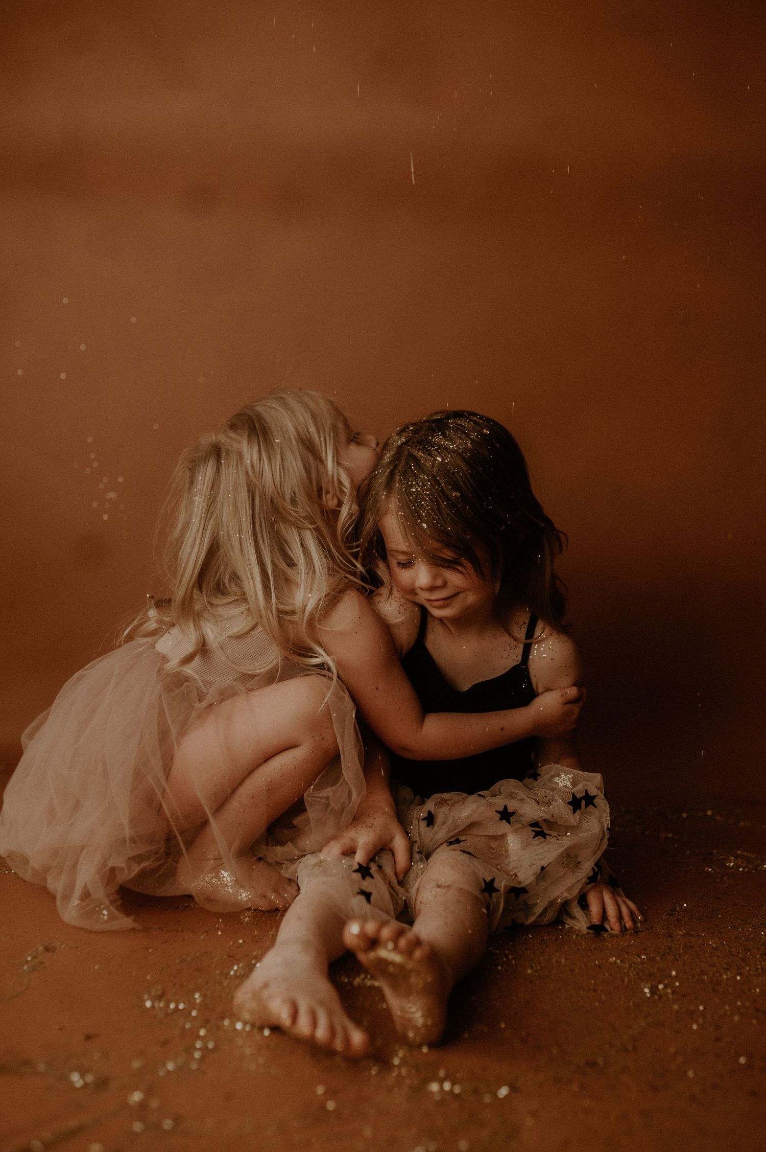 Two children in vintage sepia tones play with scattered marbles on the floor in a series of candid moments.