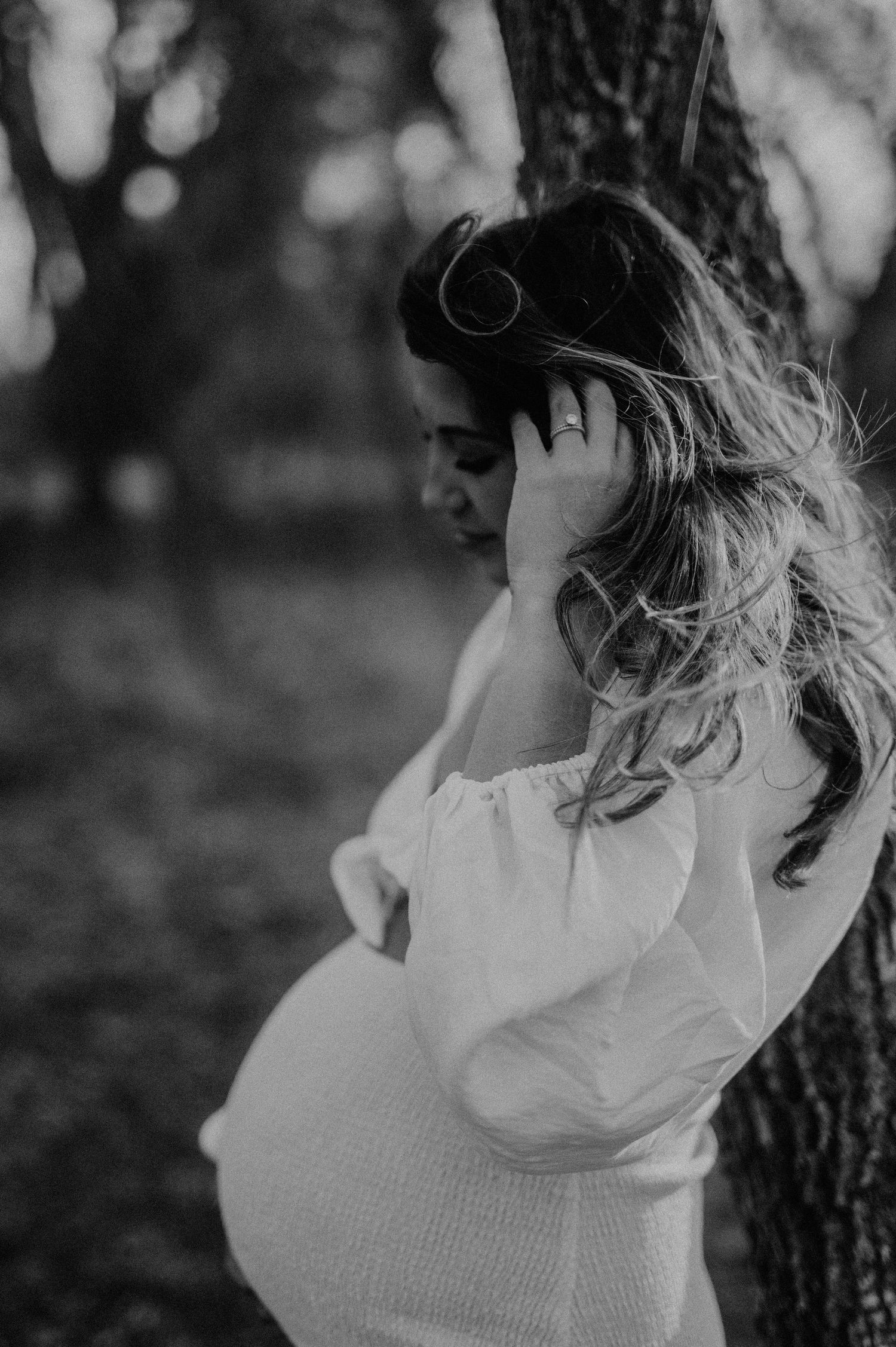 Close-up black and white maternity portrait with soft natural lighting.