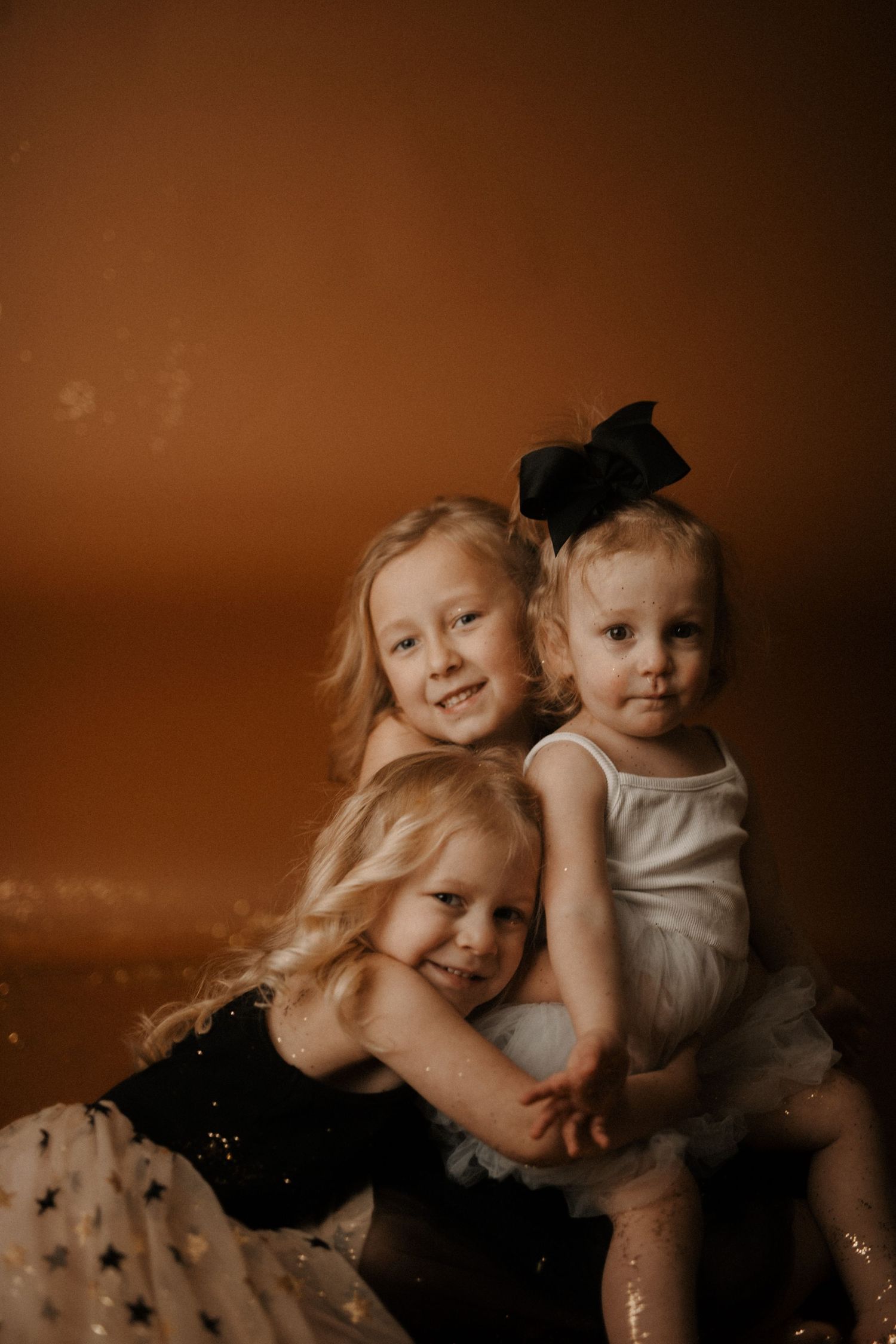 A sepia-toned artistic portrait series showing joyful expressions and playful interactions between siblings.