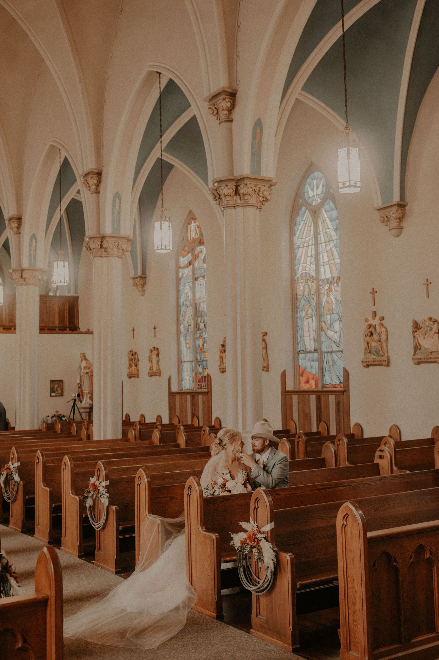 A series of candid wedding photos showing tender moments inside a beautiful cathedral with vaulted ceilings.