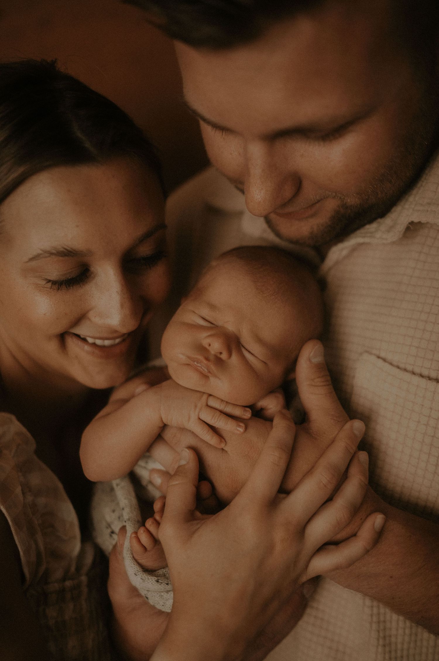 An intimate family portrait in muted tones capturing loving interactions between family members.
