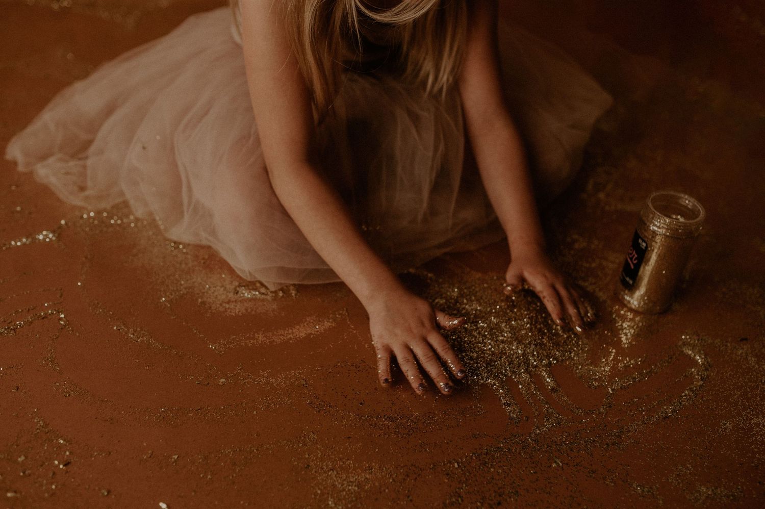 A person's hands kneading and stretching dough on a rustic wooden surface dusted with flour.