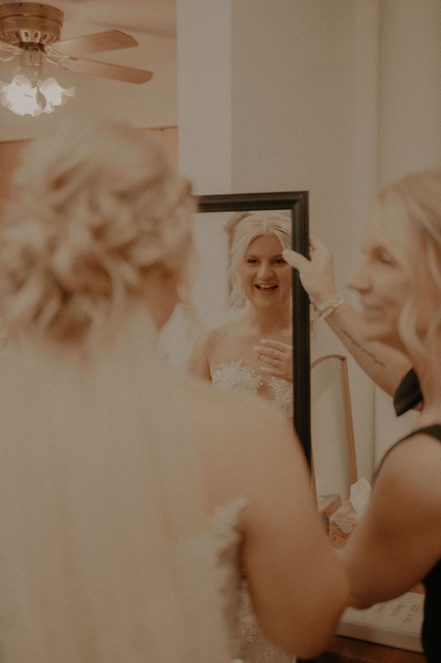 Final adjustments being made to a wedding dress in a brightly lit room.