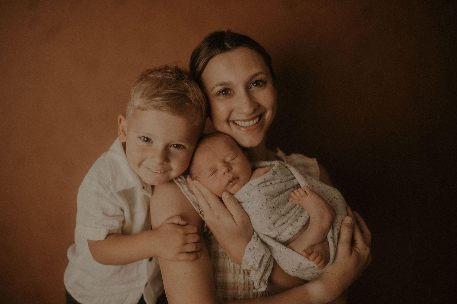 Sepia-toned family portraits showing tender moments between parent and child.