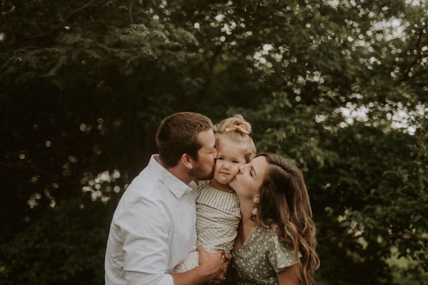 A romantic couple shares tender moments in a lush garden setting during a golden hour photo session.