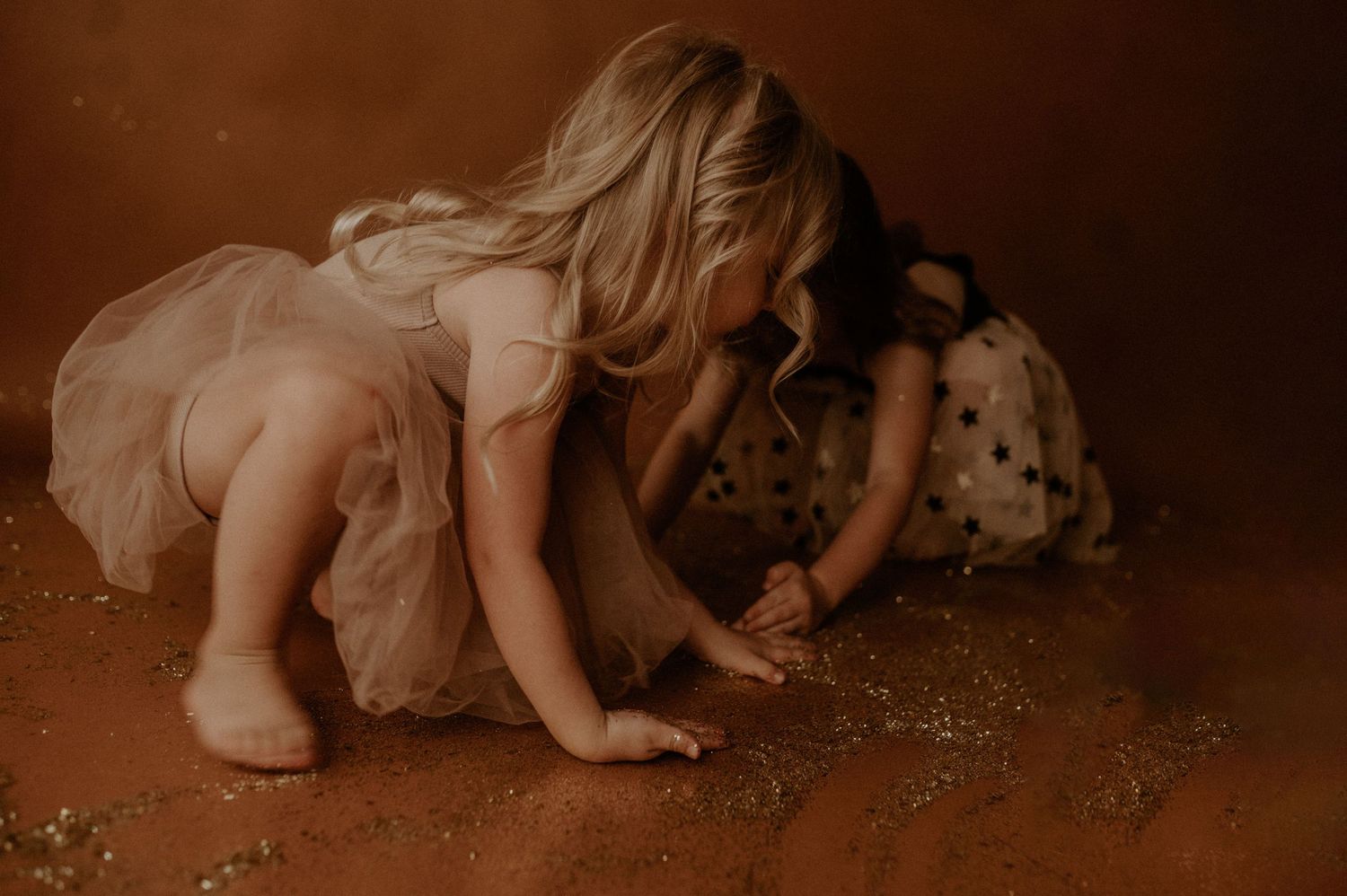 A sepia-toned series of images showing someone in a flowing dress crawling and moving on the ground.