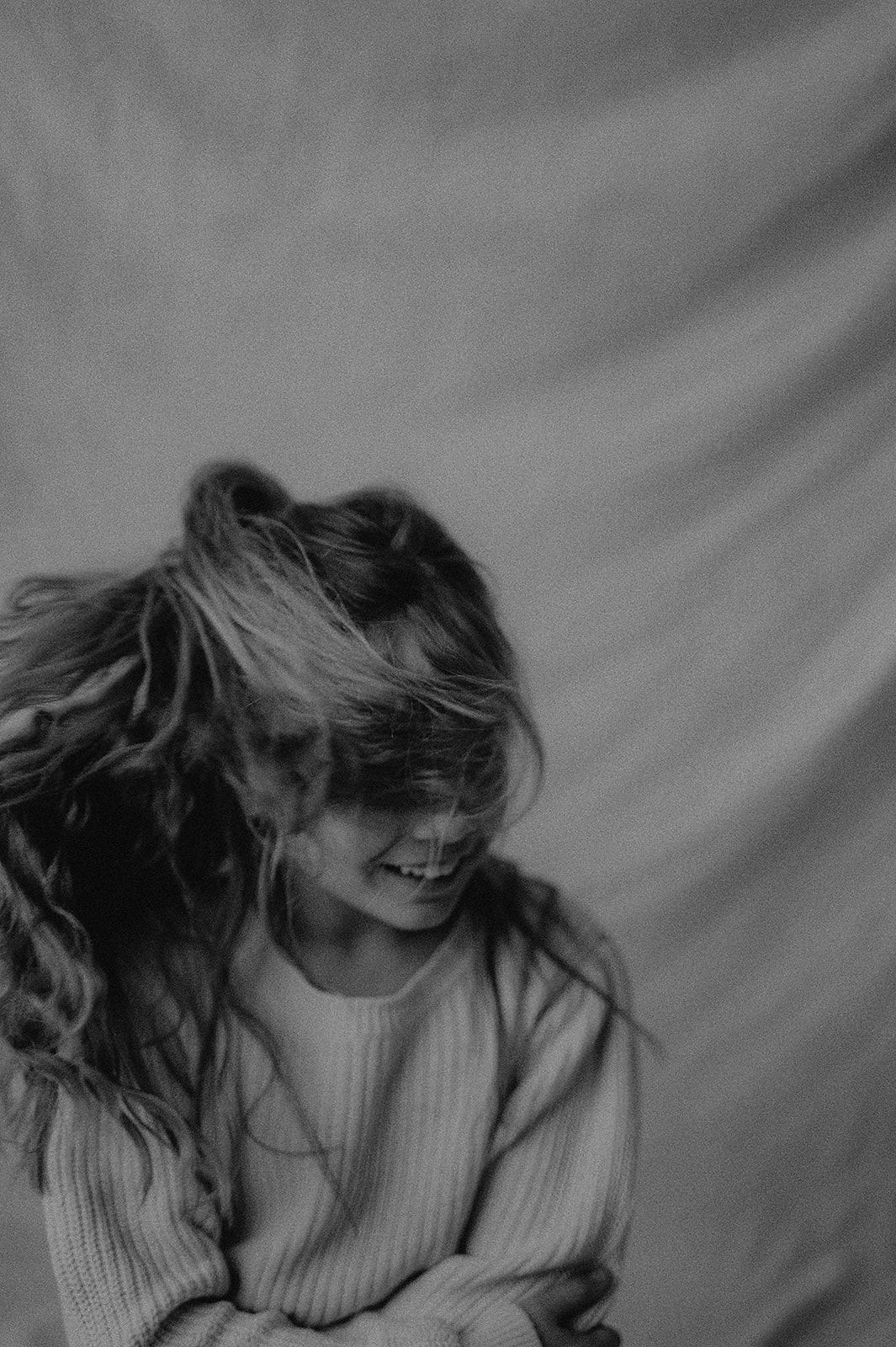 Artistic black and white photos capturing movement and emotion in soft lighting.