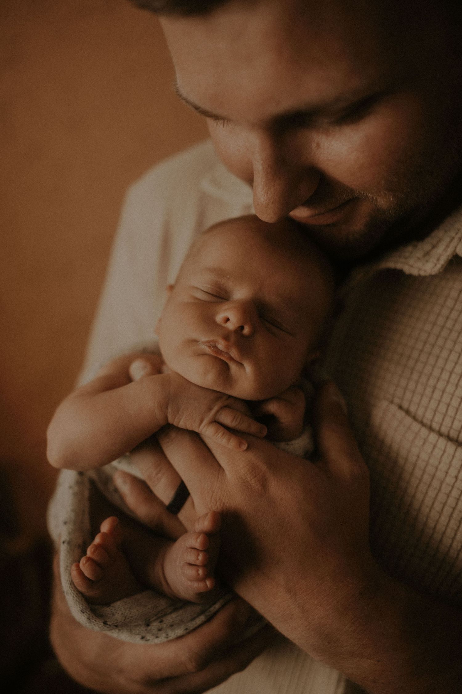 Close-up intimate portrait showing tender moments and gentle touches in warm lighting.