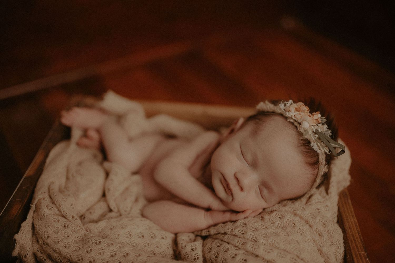 Professional newborn photography with lace wrap and vintage styling.