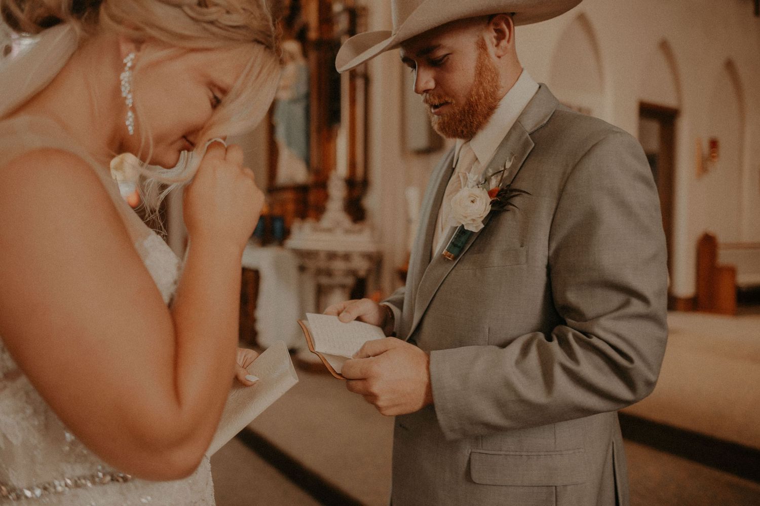 Wedding ceremony first look captured in warm tones inside an ornate cathedral setting.