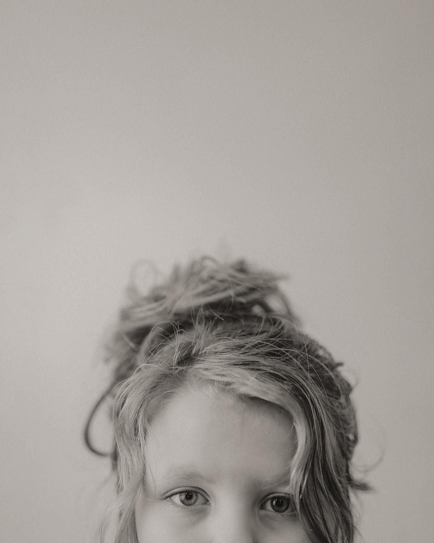 A series of black and white portraits showing close-up views of messy hair and partial facial features.