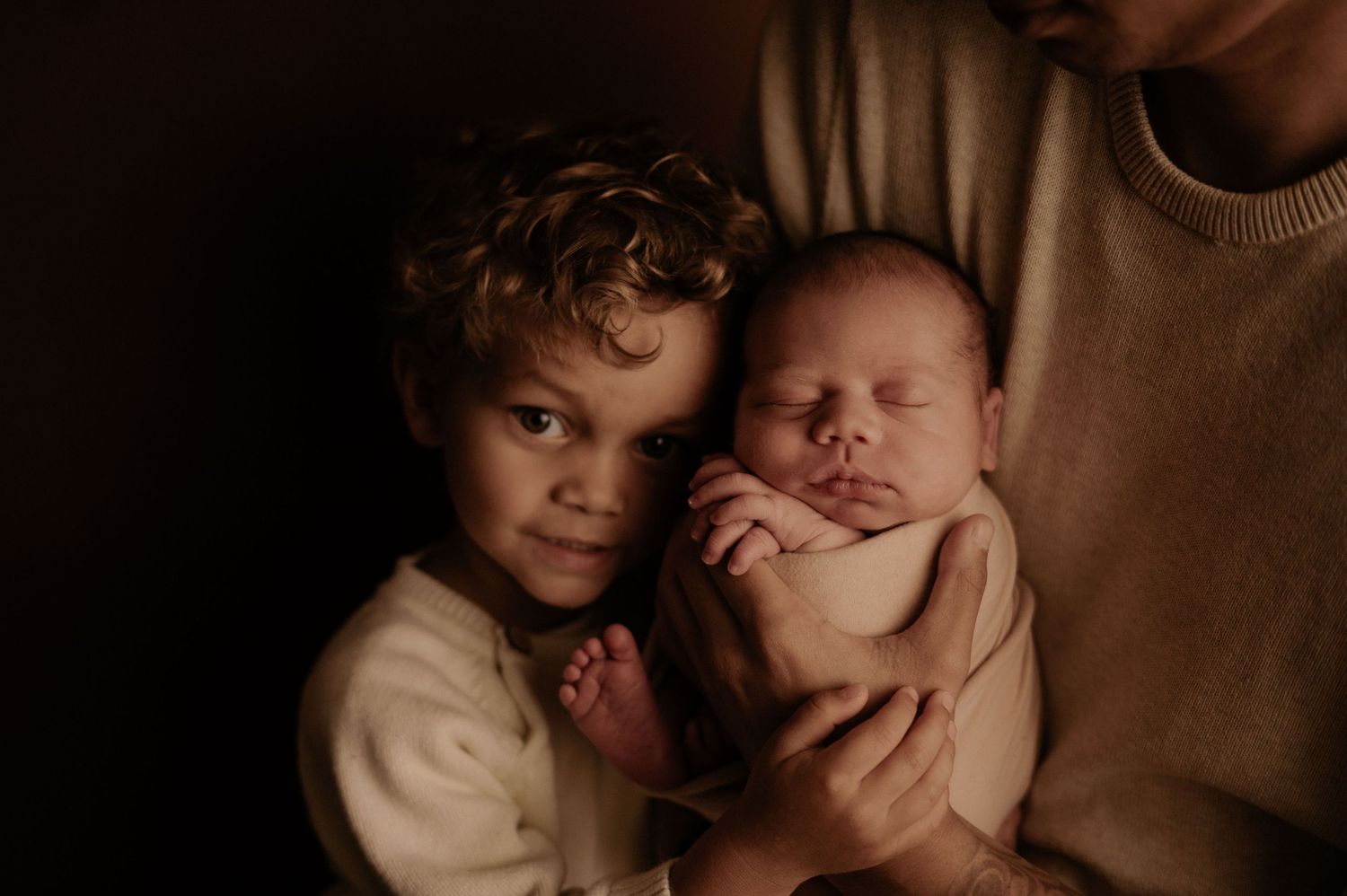 Intimate family portrait session with warm brown tones and natural expressions.