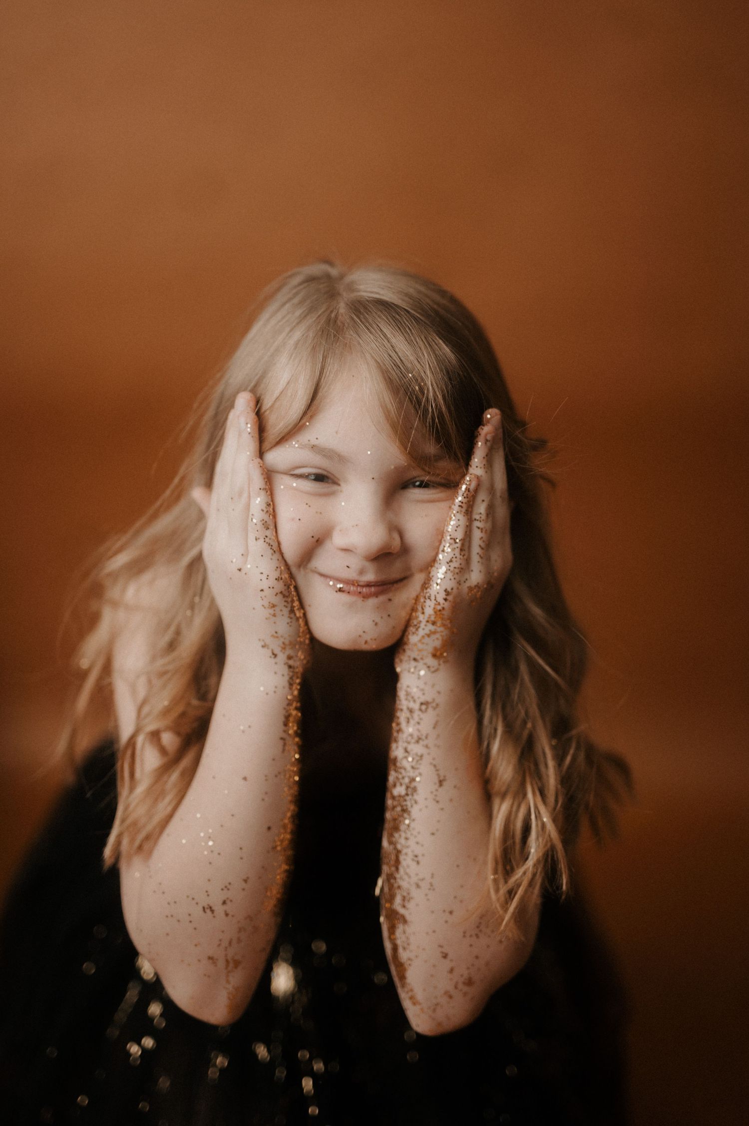 A sequence of five photos showing hands covering eyes with glitter-covered fingers against a warm brown background.