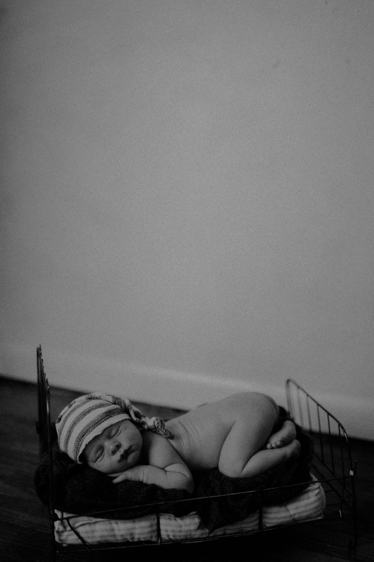 A black and white sequence of five images showing someone sleeping on a bed in different positions.