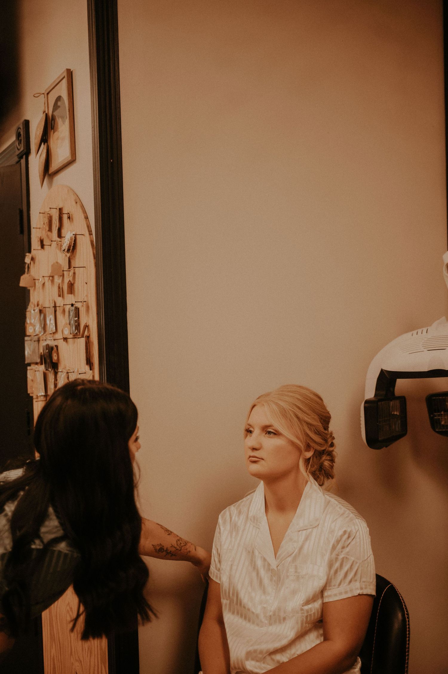 A makeup application session captured in warm, vintage-style lighting.