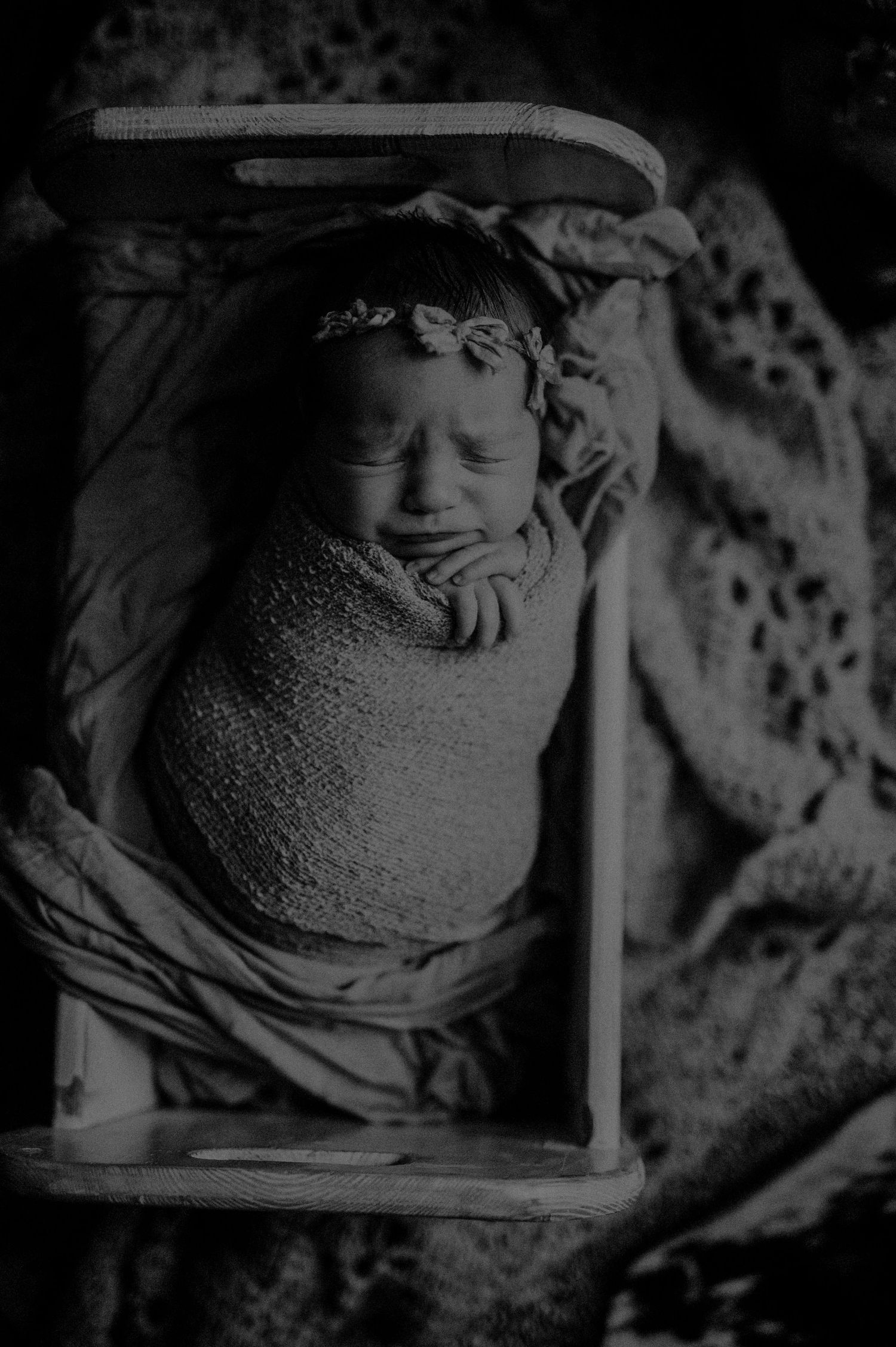 Black and white photograph of a cherubic stone sculpture detail with flowing drapery in classical architectural style.