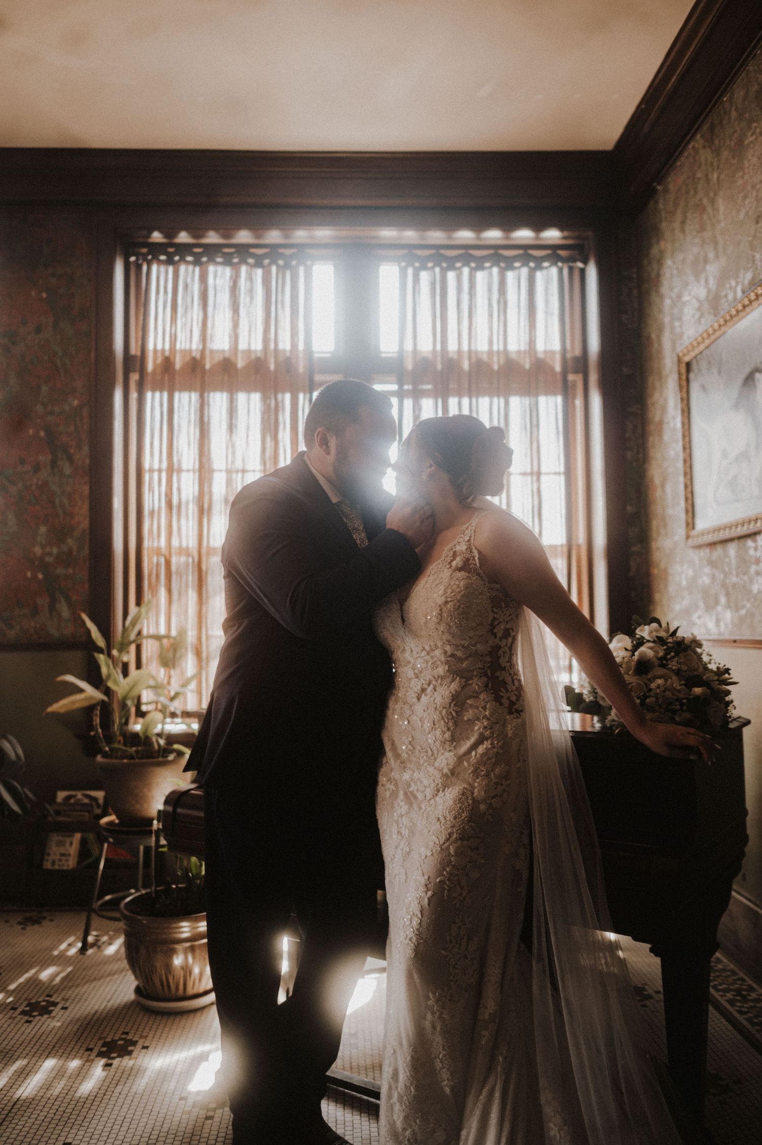 Intimate wedding photography moments captured in warm, filtered light through vintage windows.