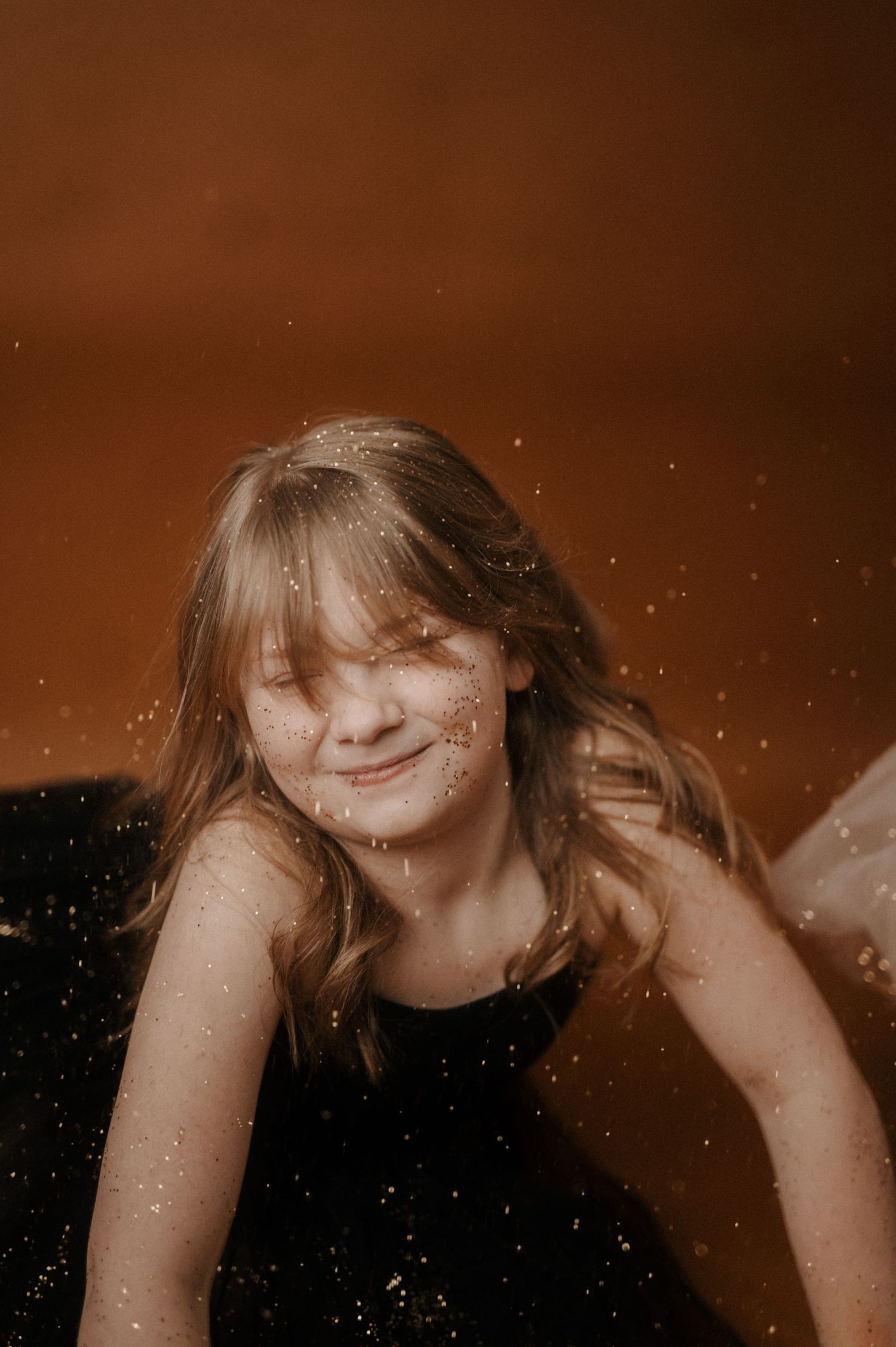 A series of sepia-toned portraits showing a person with long hair in various poses against a dark background.