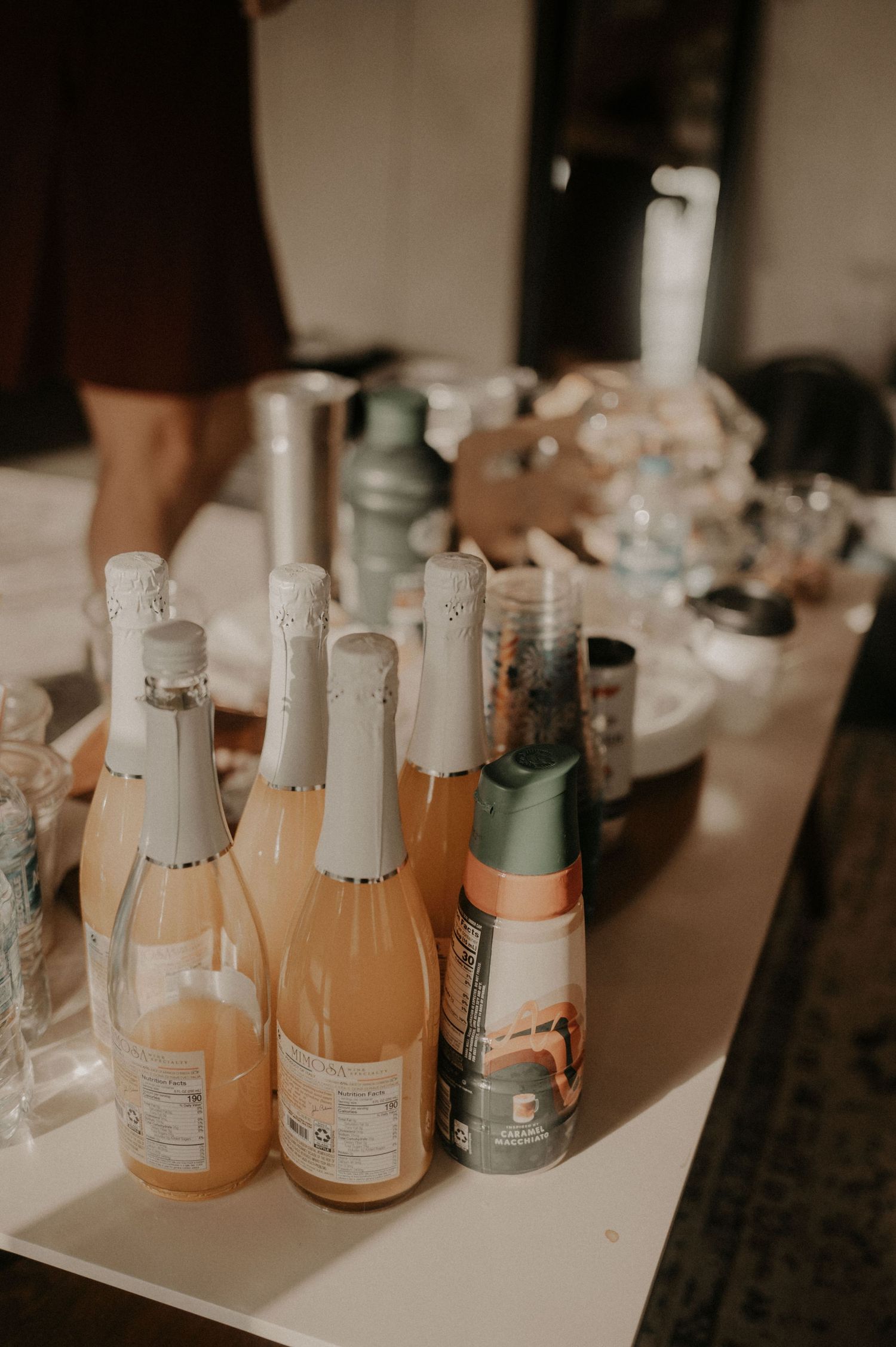 Bottles of champagne and wine arranged on a white surface at an event.