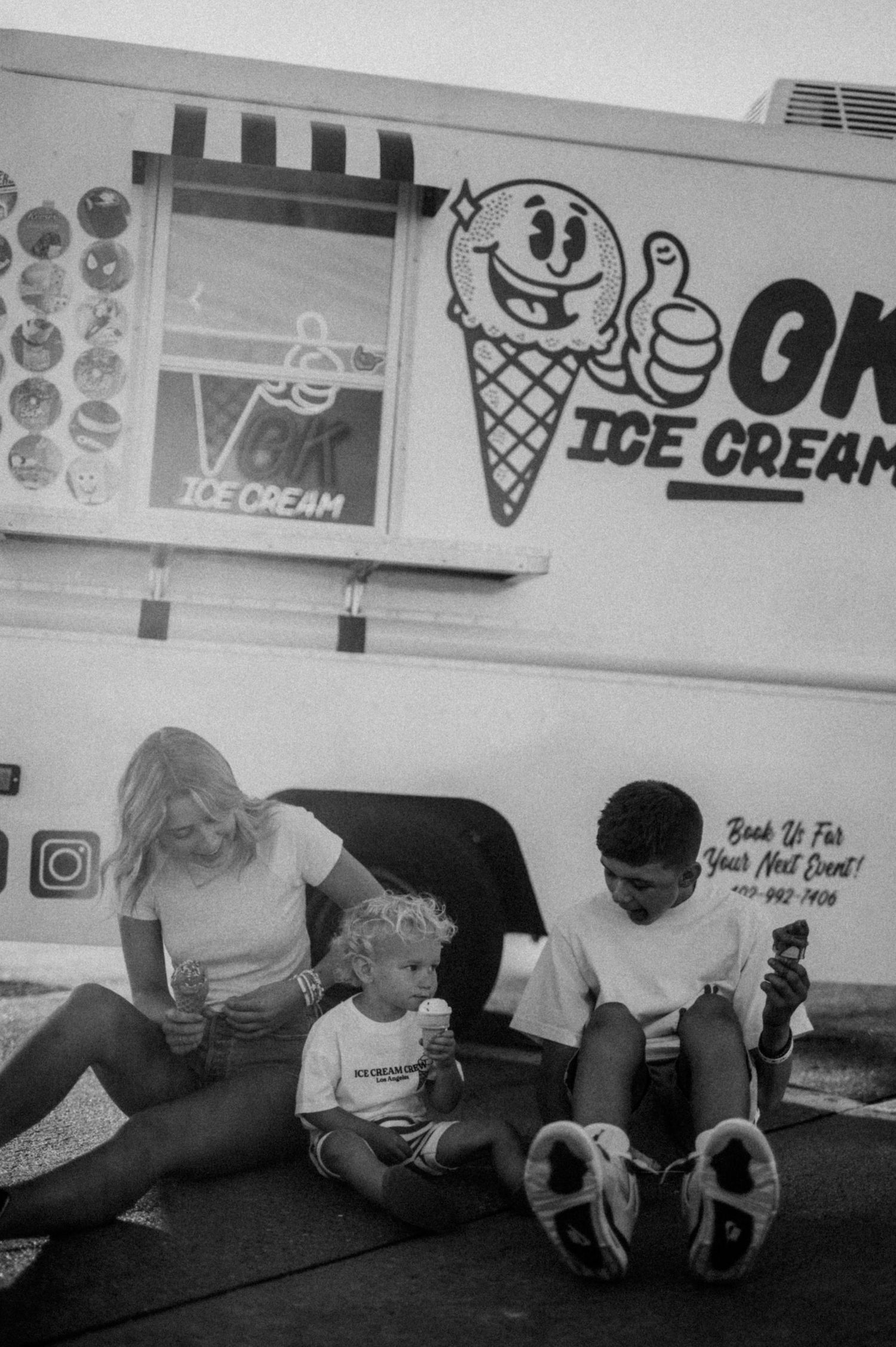People lying on floor beneath ice cream shop wall decorations in black and white.