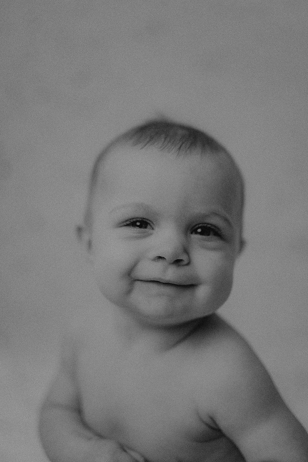 Sweet black and white portraits of a smiling baby showing different expressions.