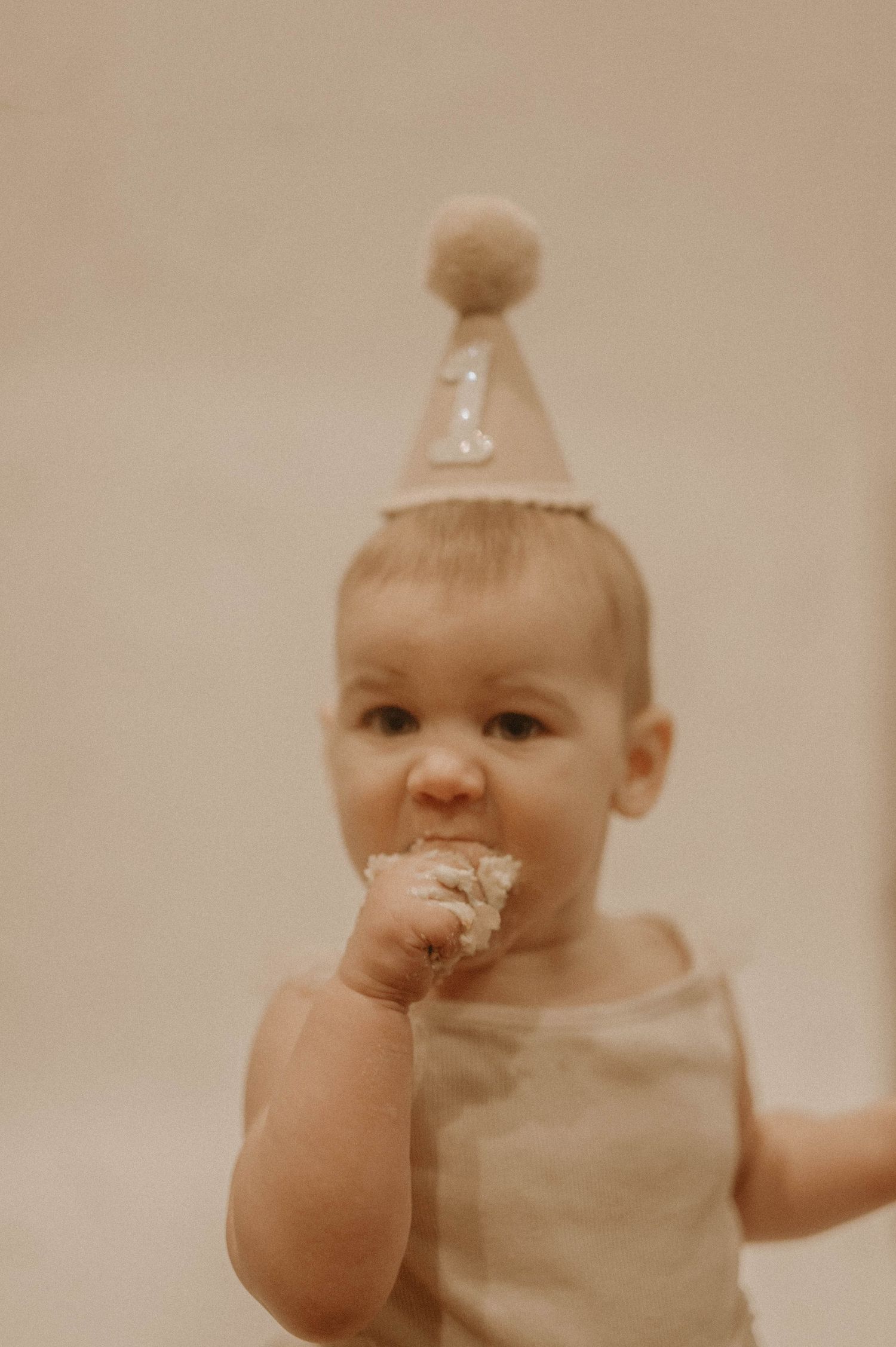 A series of sepia-toned photos showing a baby wearing light colored clothing against a neutral background.