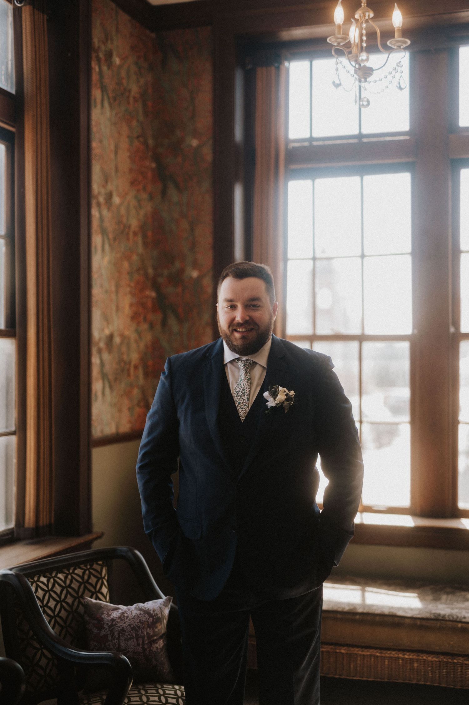 A formal room with rustic windows and warm lighting creates an elegant wedding day atmosphere.