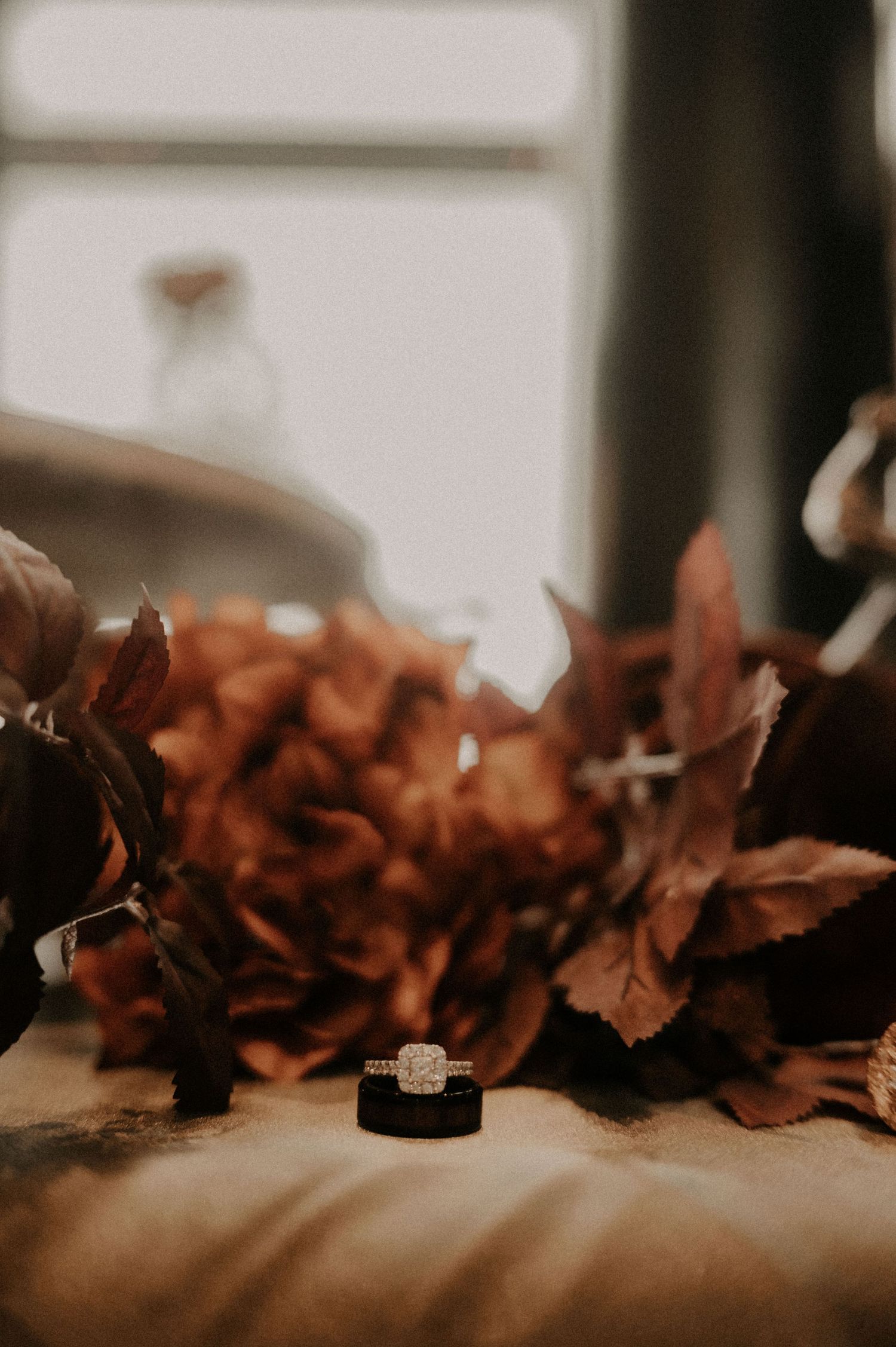 Autumn leaves create a decorative border against a soft blurred background.