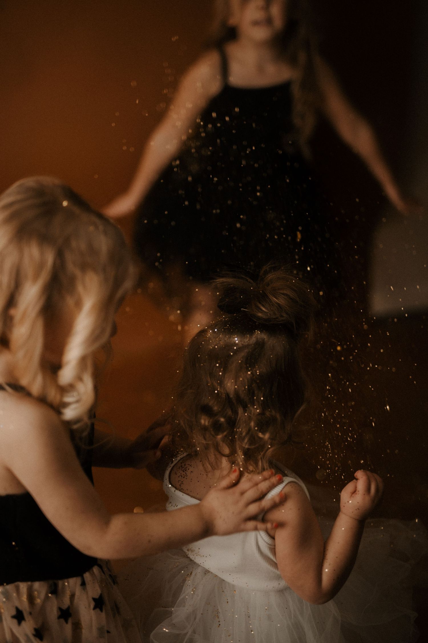 People in formal attire dance together in a moody, atmospheric setting with glittering particles in the air.