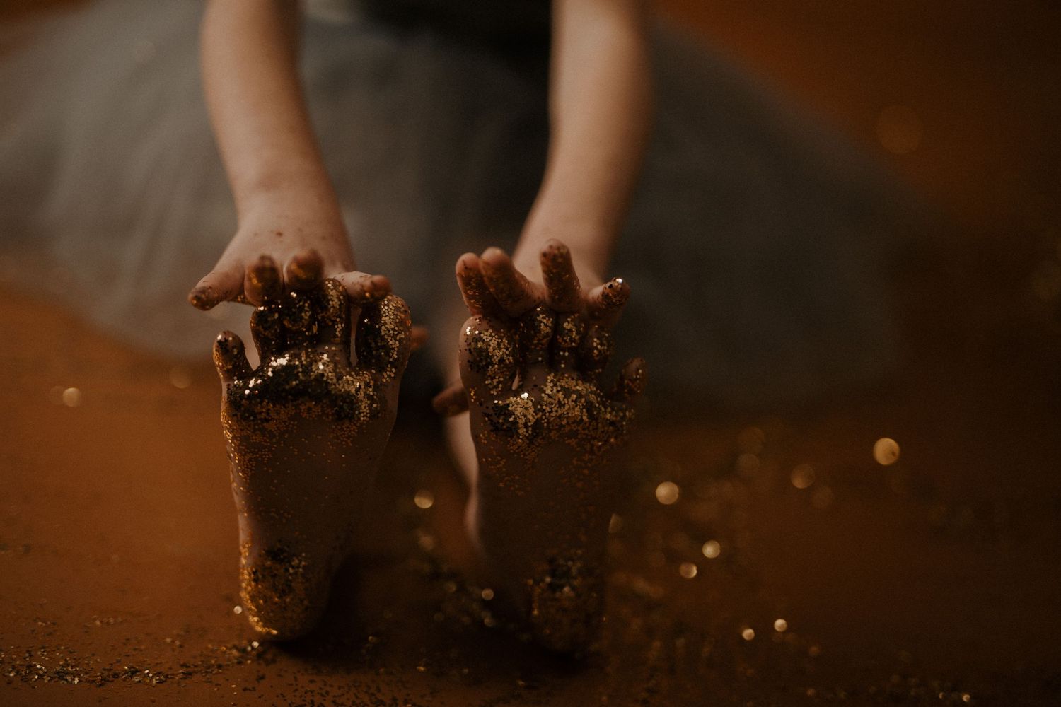 Hands breaking apart chocolate muffins to reveal moist, crumbly texture against dark background.
