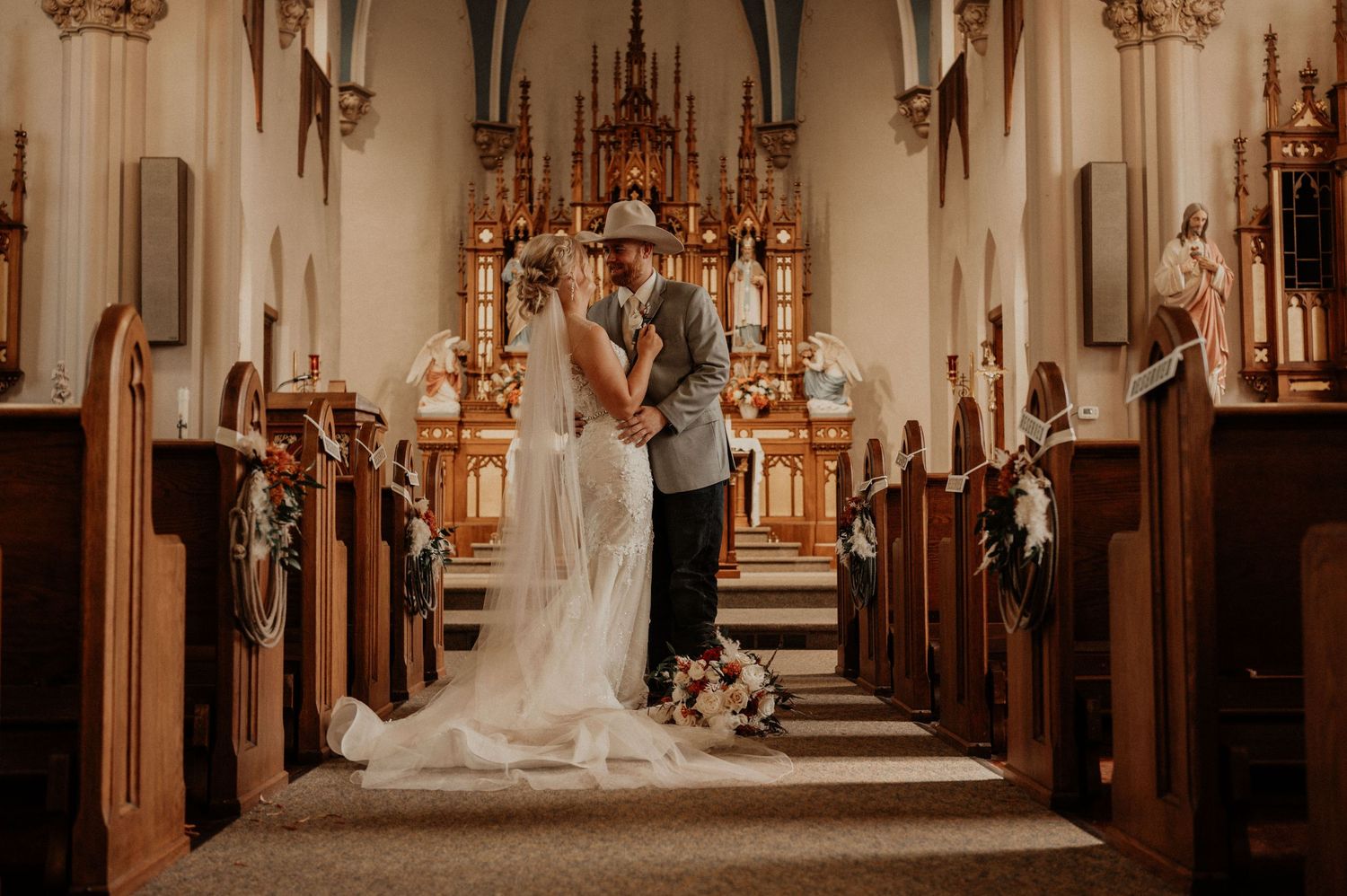 Interior view of a traditional Catholic church during a wedding ceremony with elegant altar decorations.