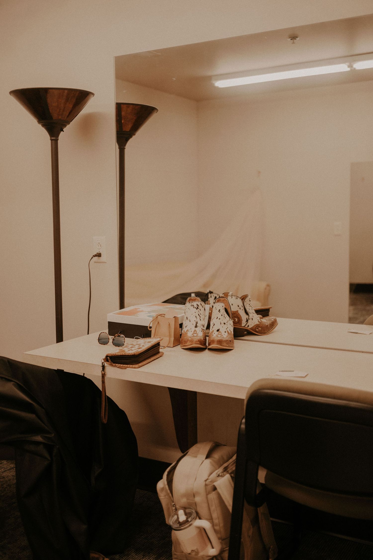 Floor lamps and furniture arranged in an empty dressing room space.